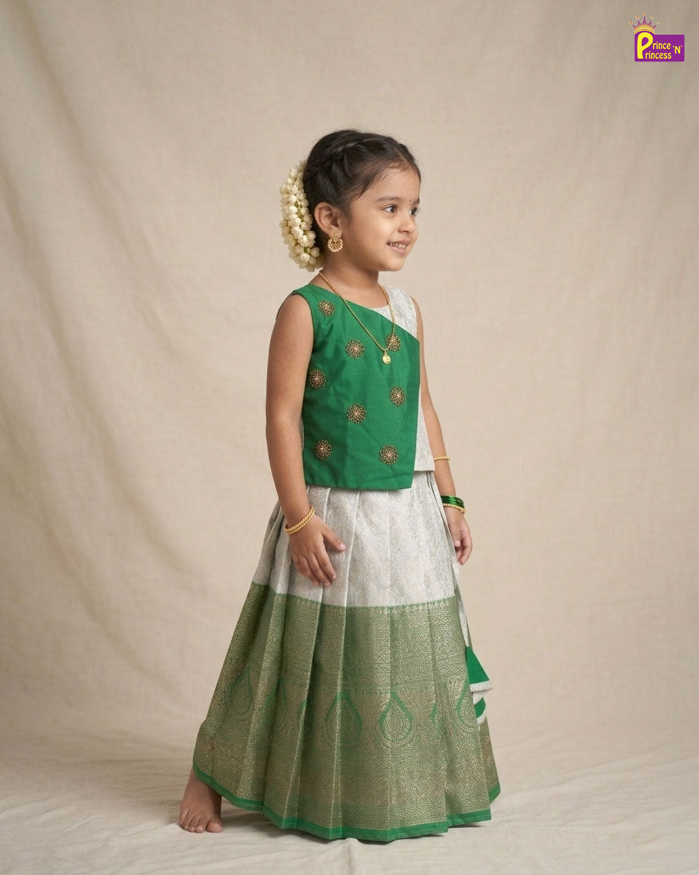 Young girl in a green and white traditional outfit on a beige background - Prince N Princess