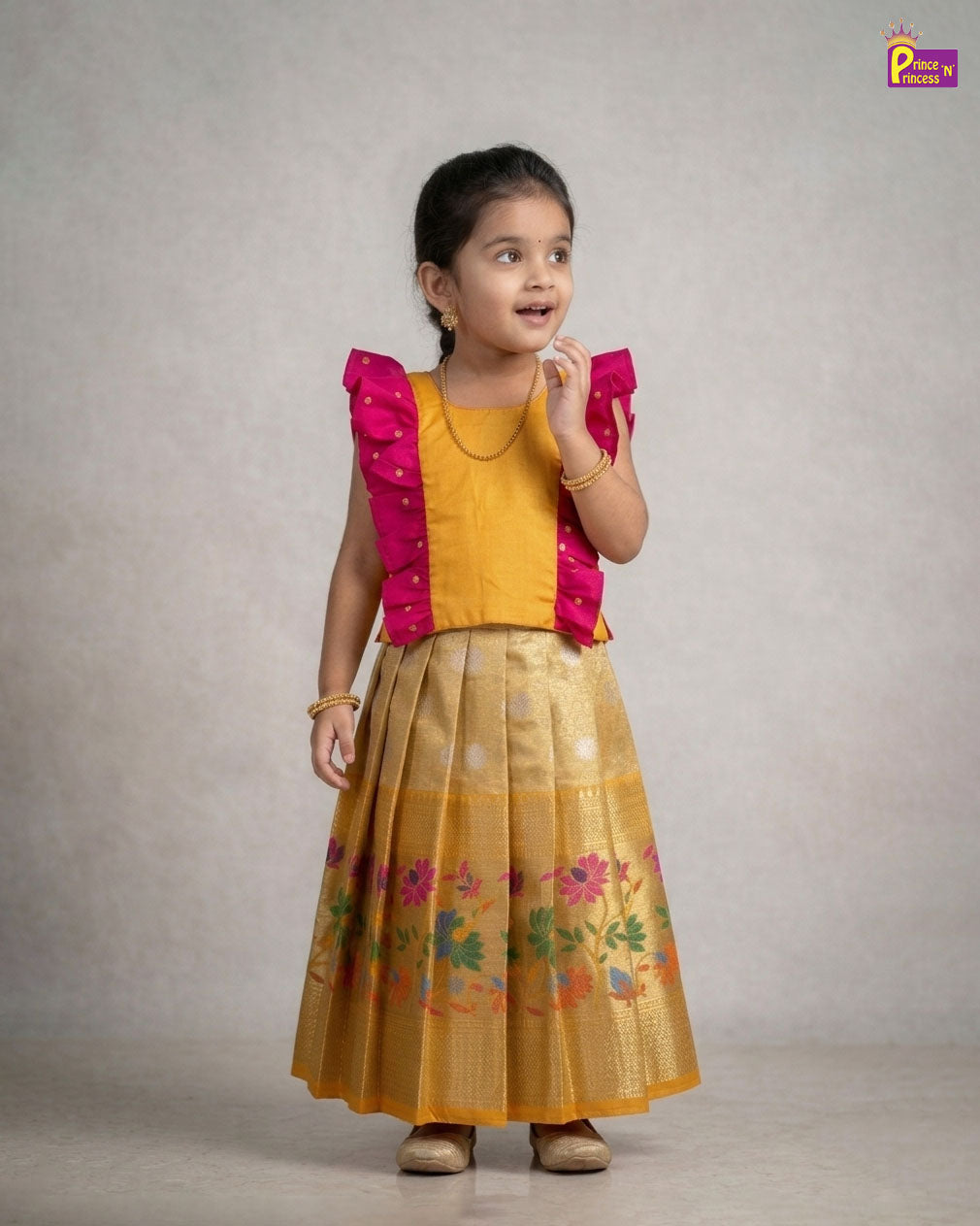 Young girl wearing a yellow dress with pink accents against a plain background - Prince N Princess