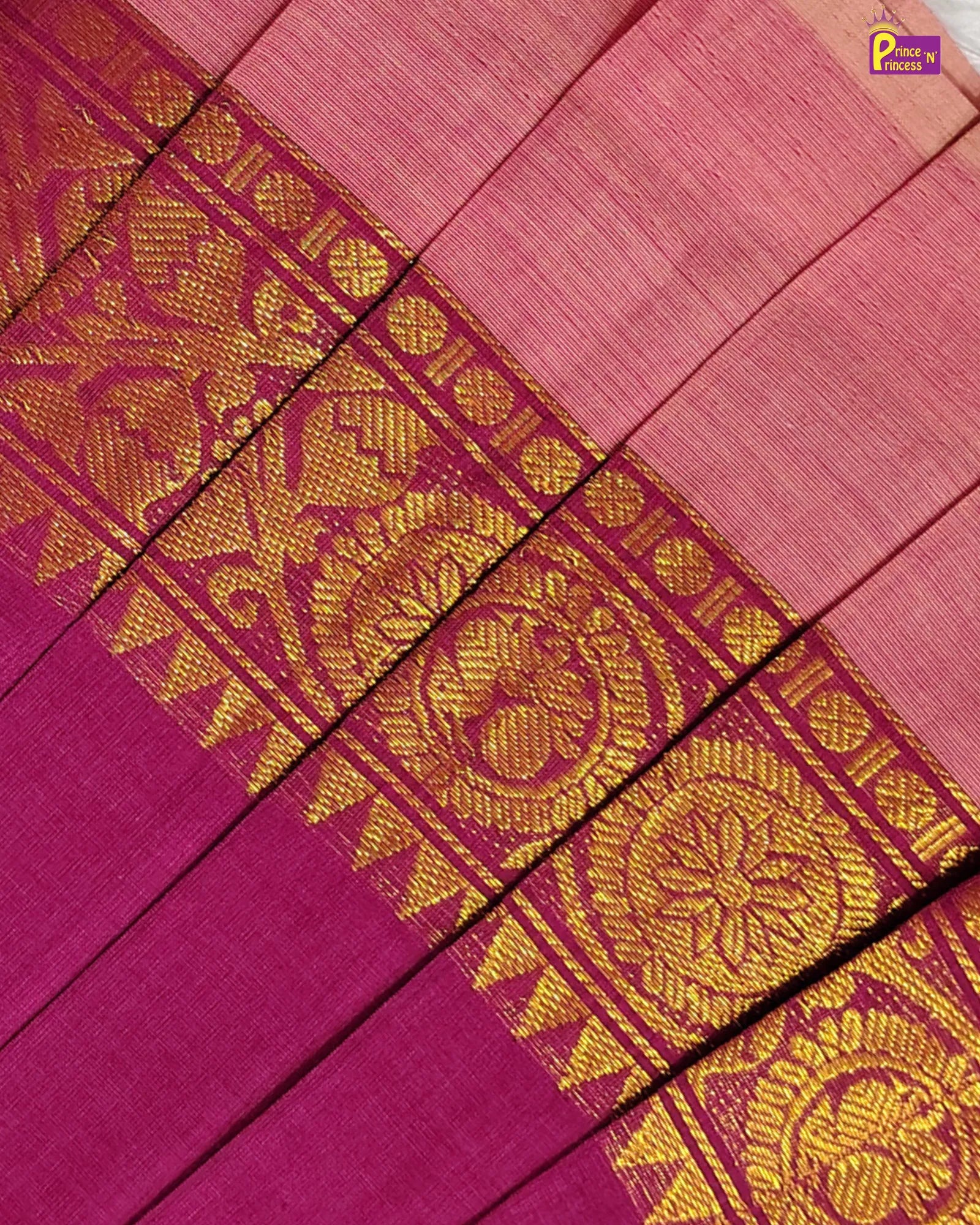 A close-up of a pink and magenta fabric with a wide gold woven border featuring floral and geometric patterns.