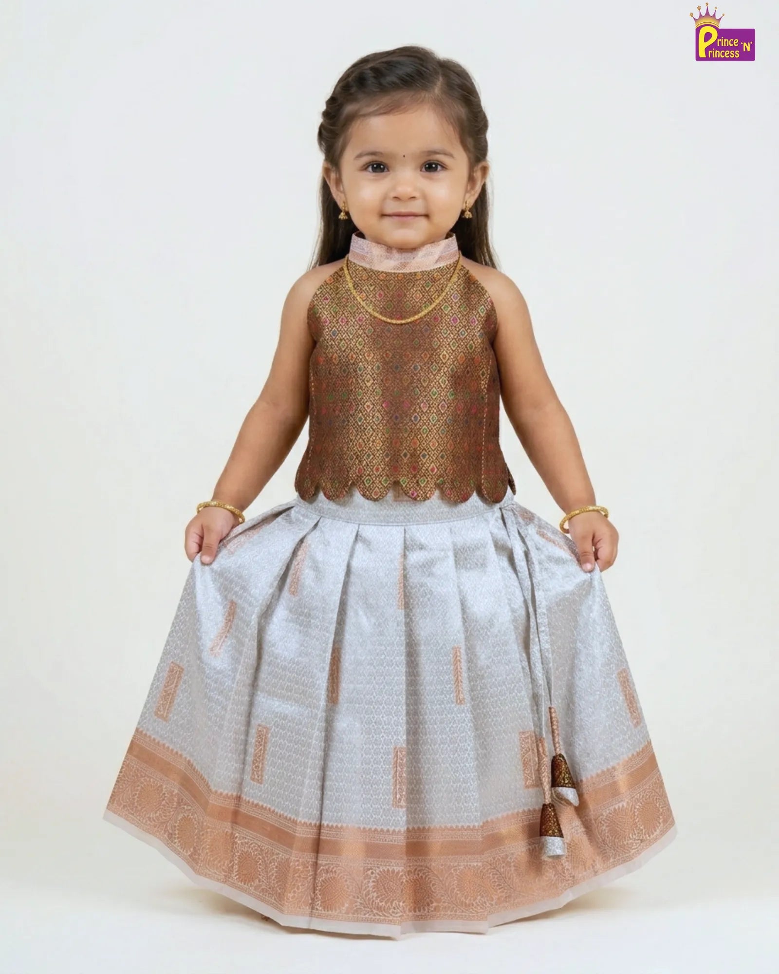 Young girl wearing a traditional outfit with a gold top and white skirt on a white background