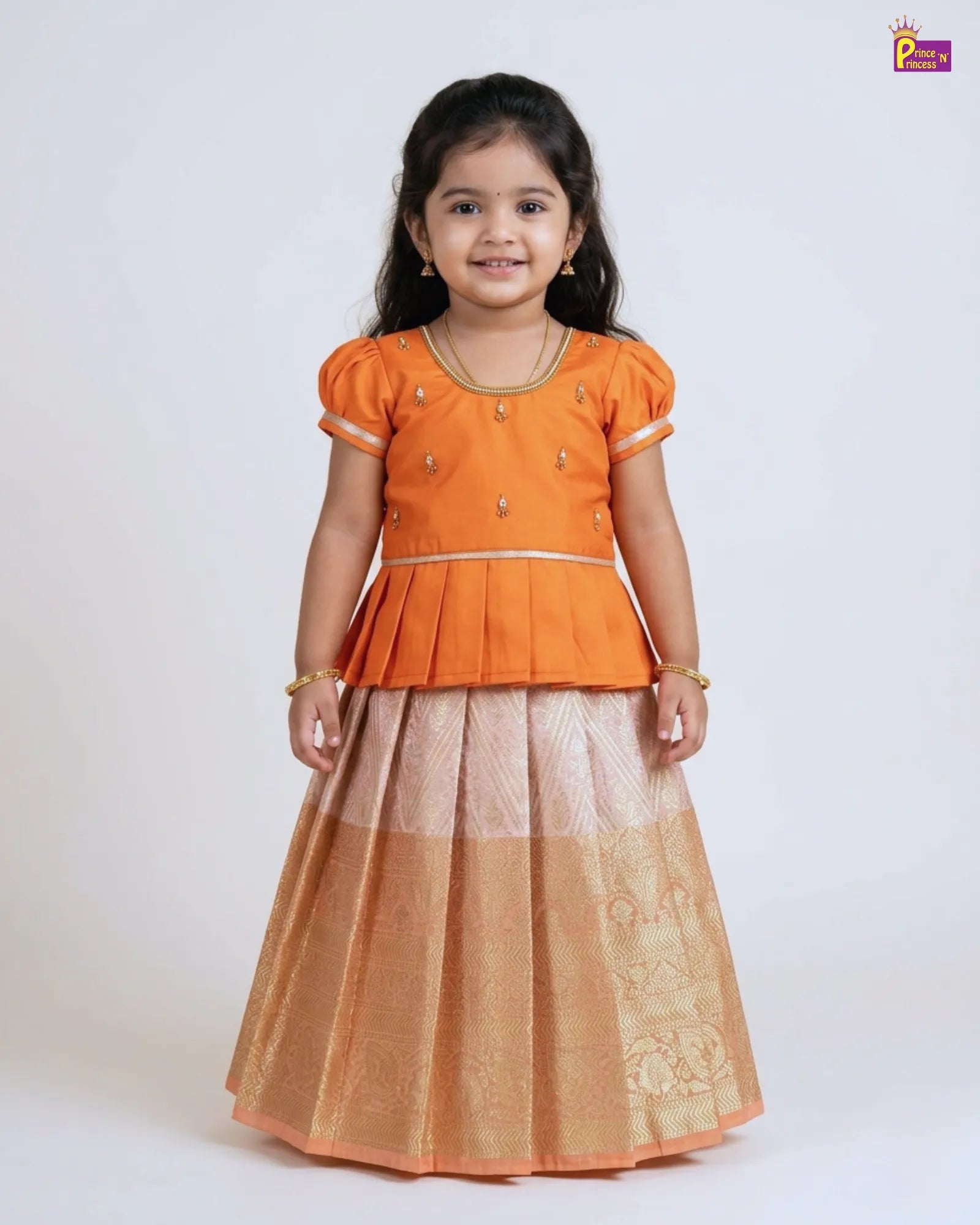 Young girl wearing an orange top and beige skirt on a white background