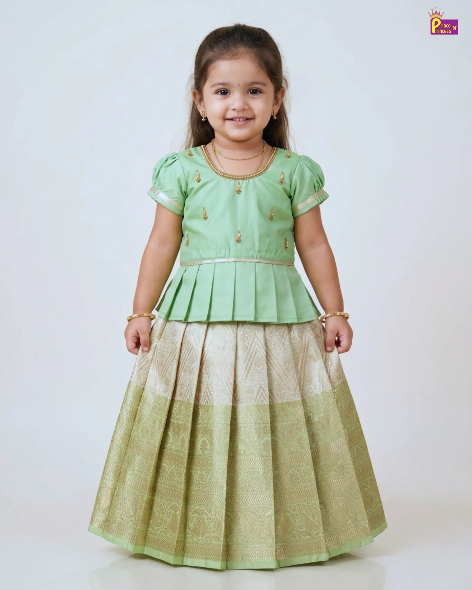 Young girl wearing a green traditional outfit with a white background