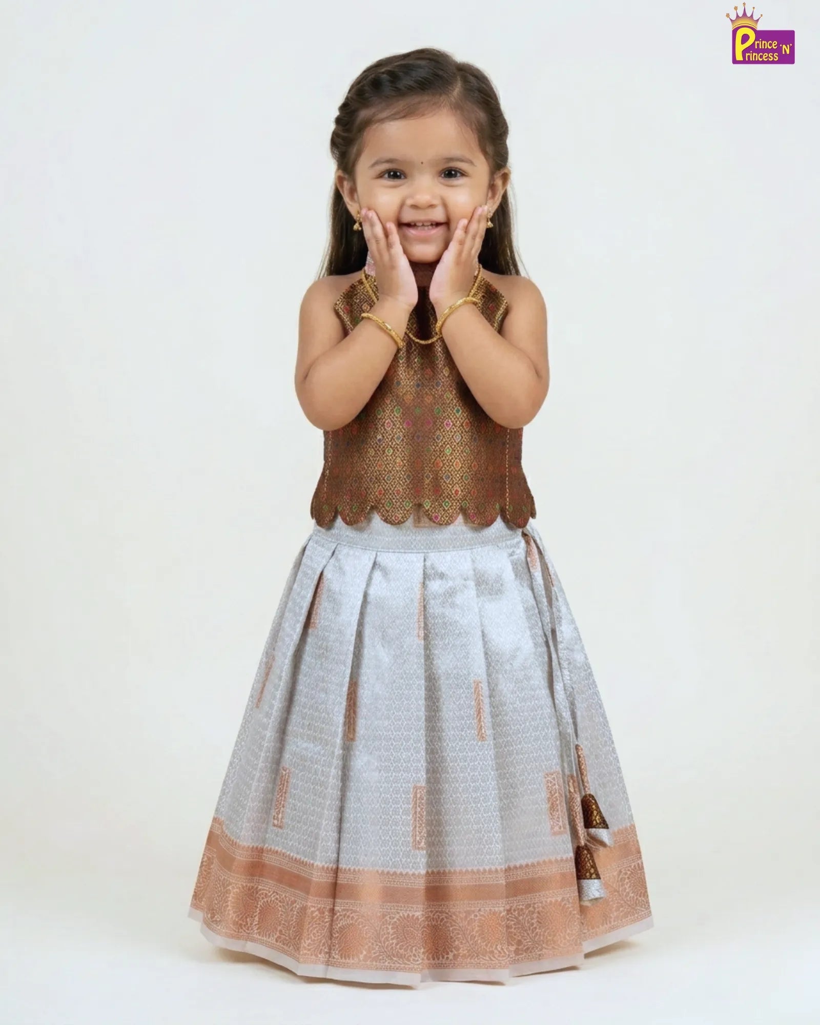 Young girl wearing a traditional outfit with a white and brown patterned dress on a white background