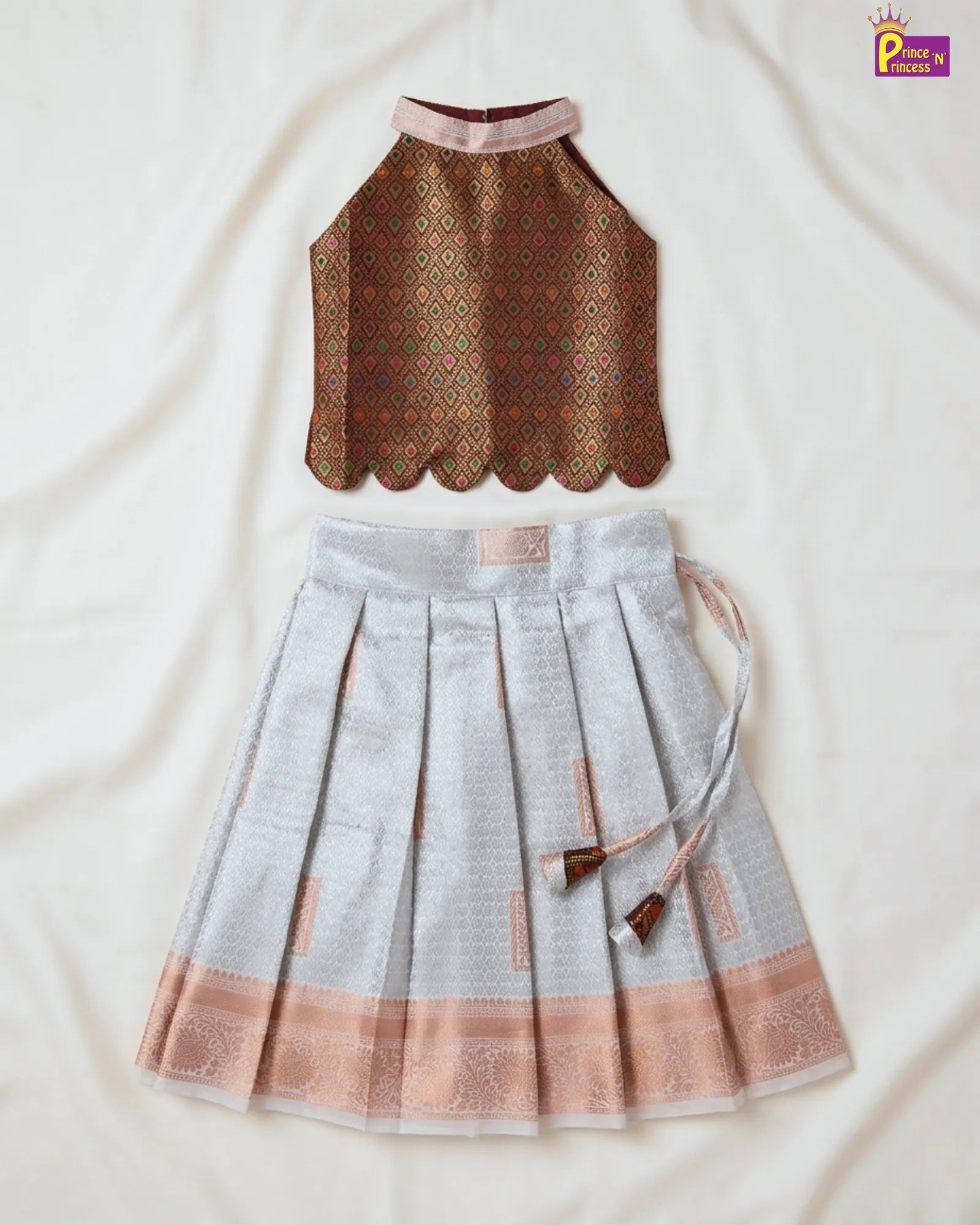 Traditional outfit with a patterned top and pleated skirt on a light background
