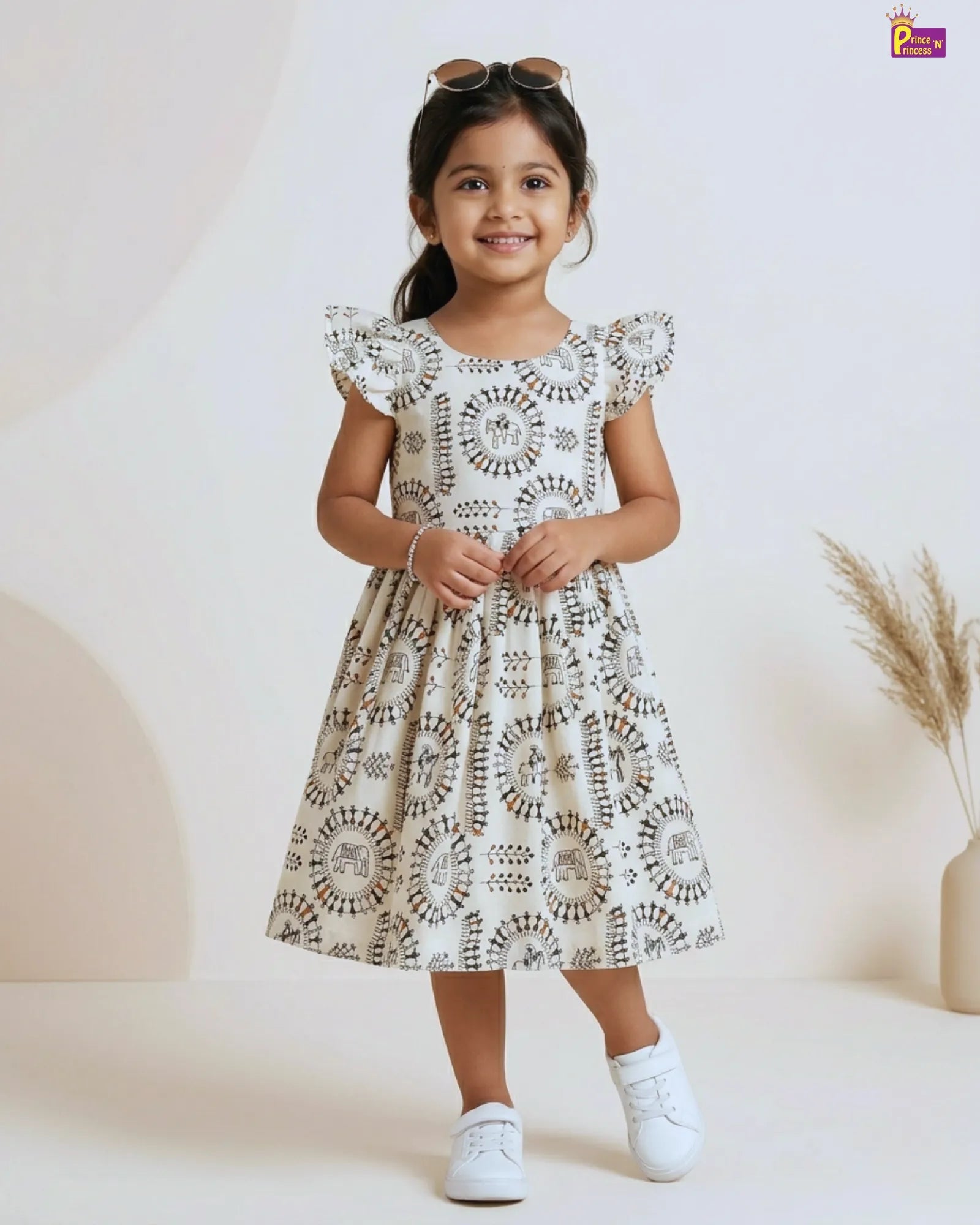Young girl wearing a white dress with black patterns on a white background