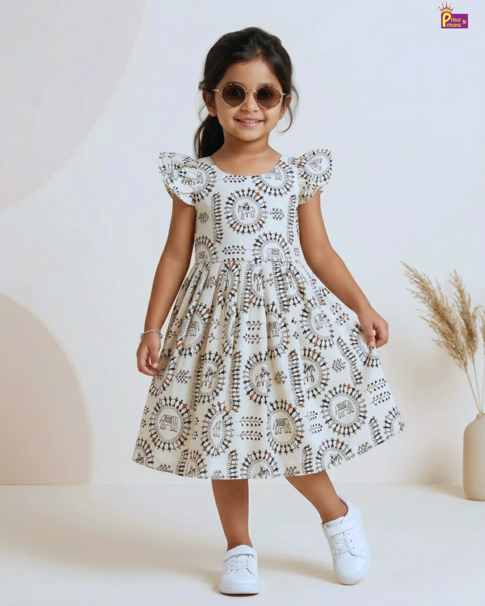 Young girl wearing a white dress with black patterns on a white background