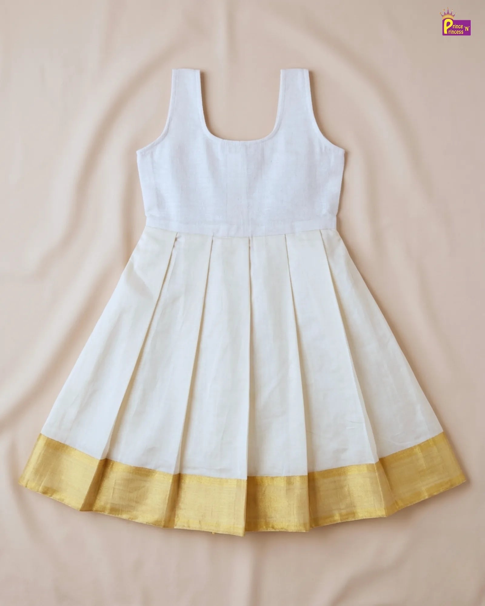 White dress with gold hem on a beige background