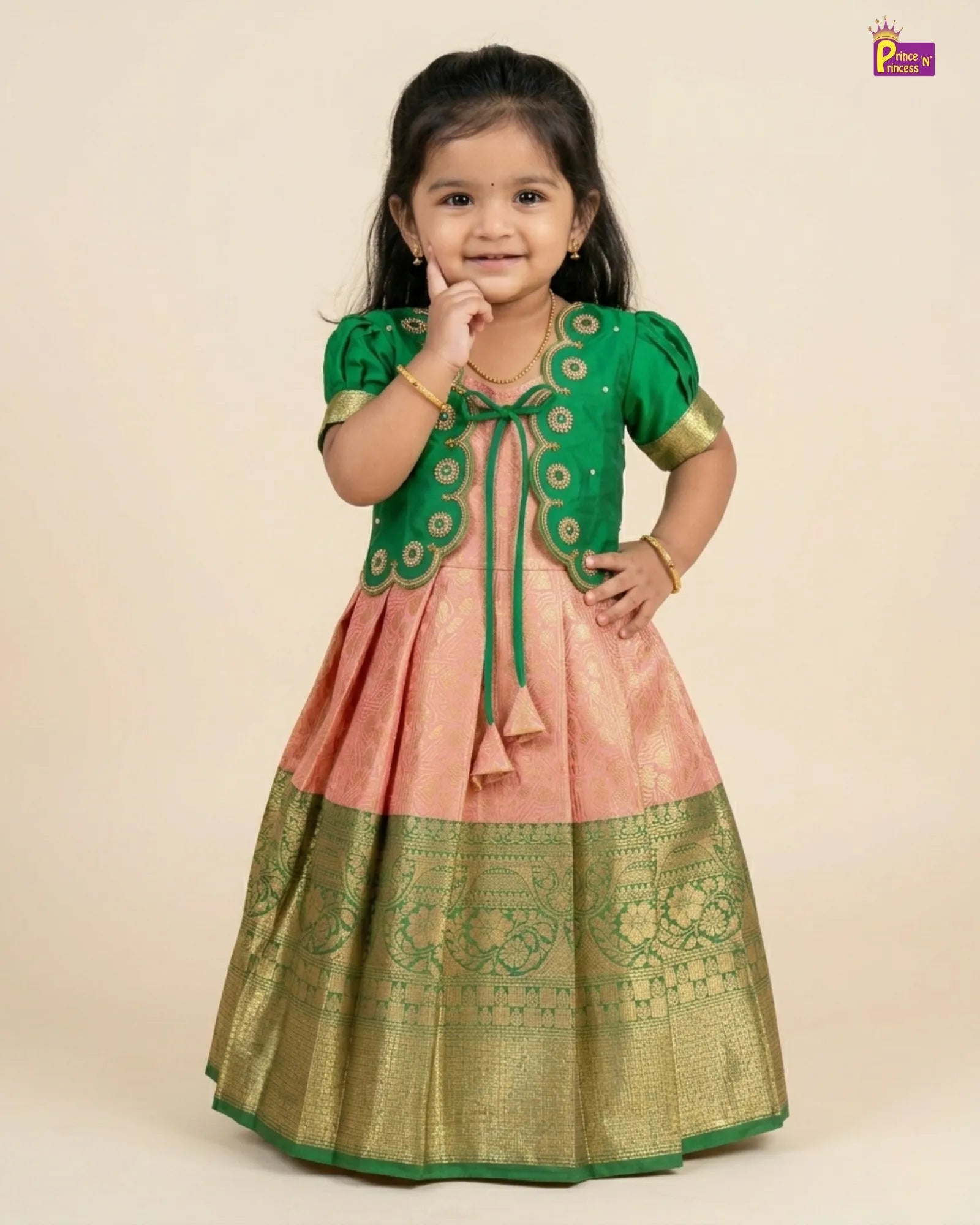 Young girl wearing a green and pink traditional outfit on a beige background