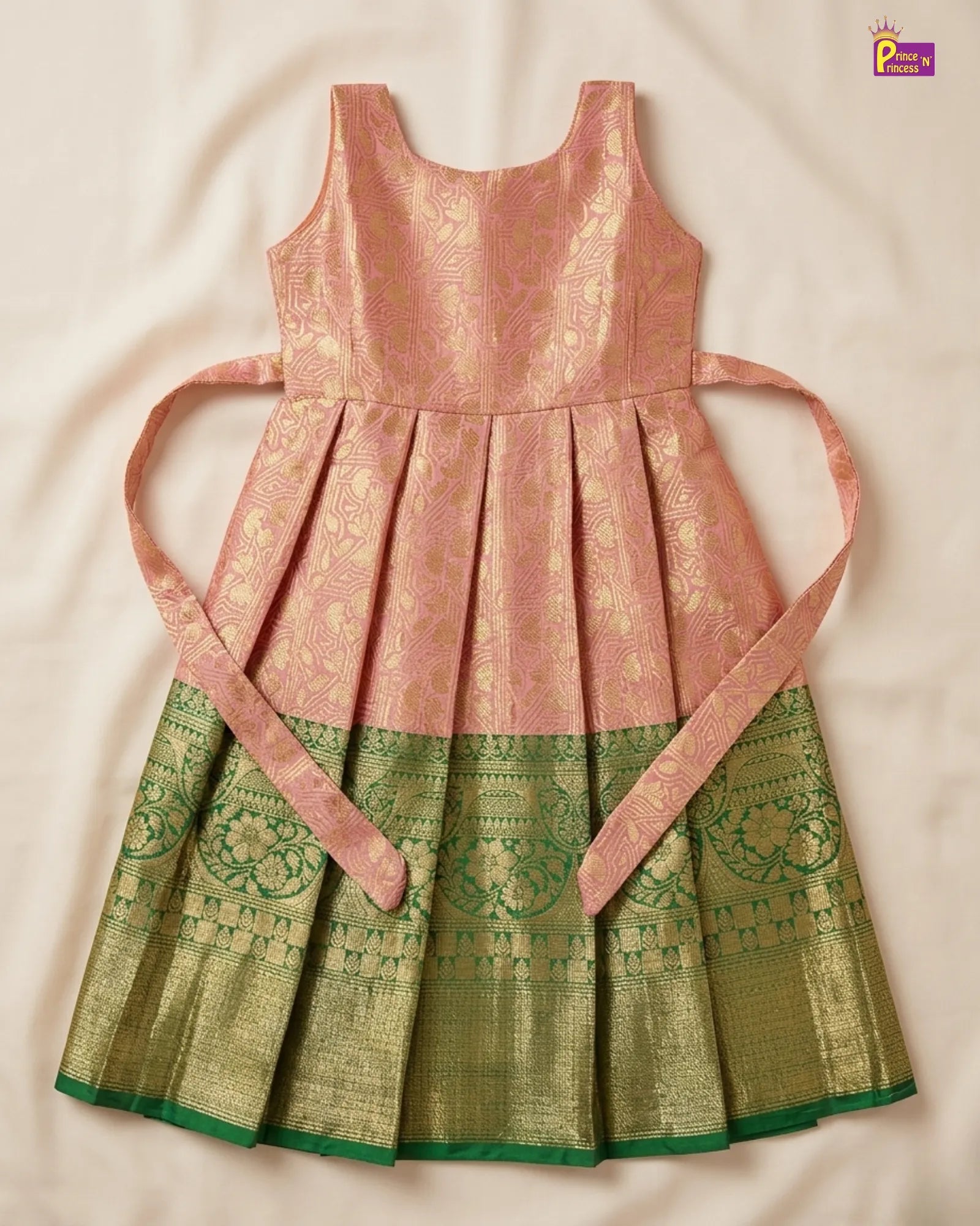 Traditional dress with pink top and green bottom on a beige background