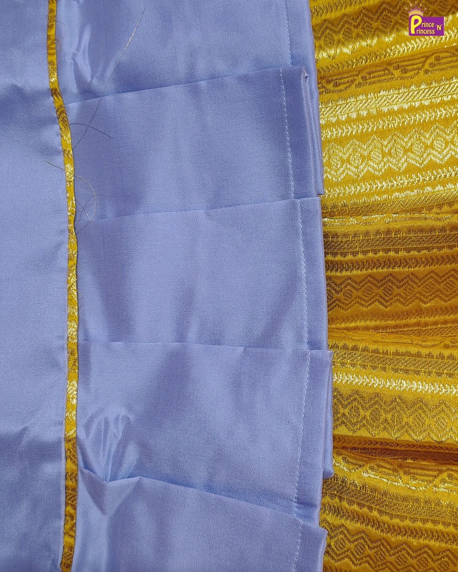 Close-up of a blue fabric with a yellow border against a yellow patterned background