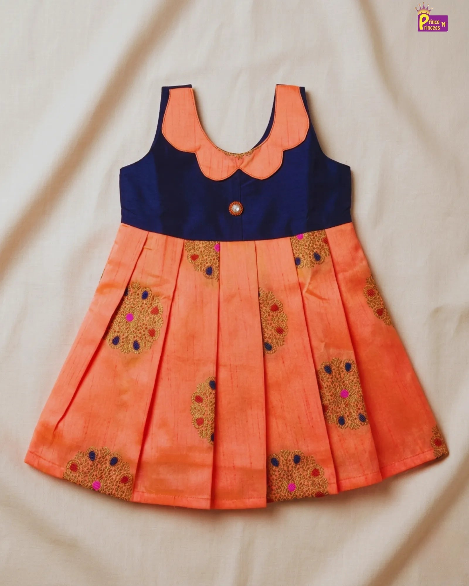 Orange dress with blue top on a beige fabric background