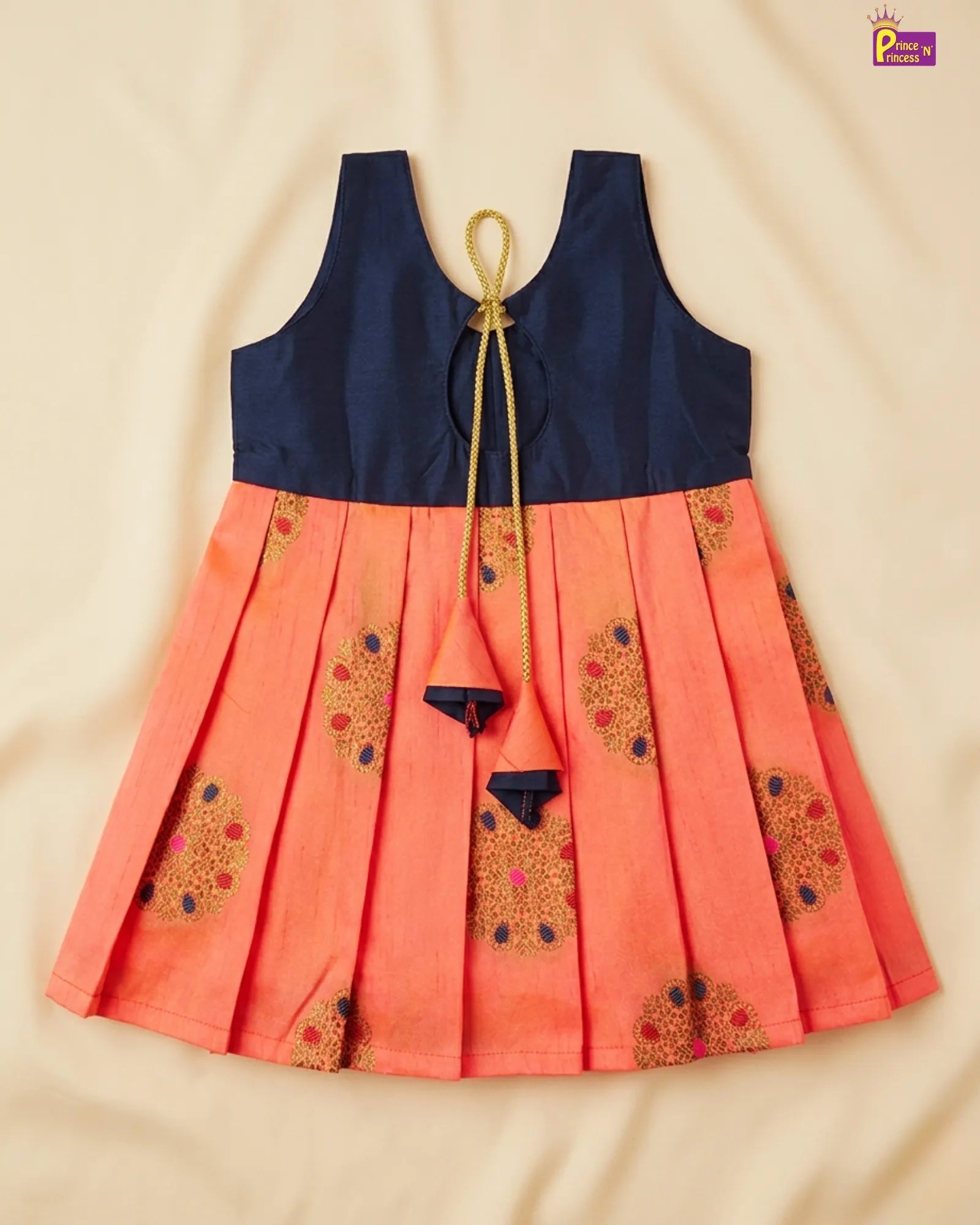 Orange dress with navy blue top on a beige background
