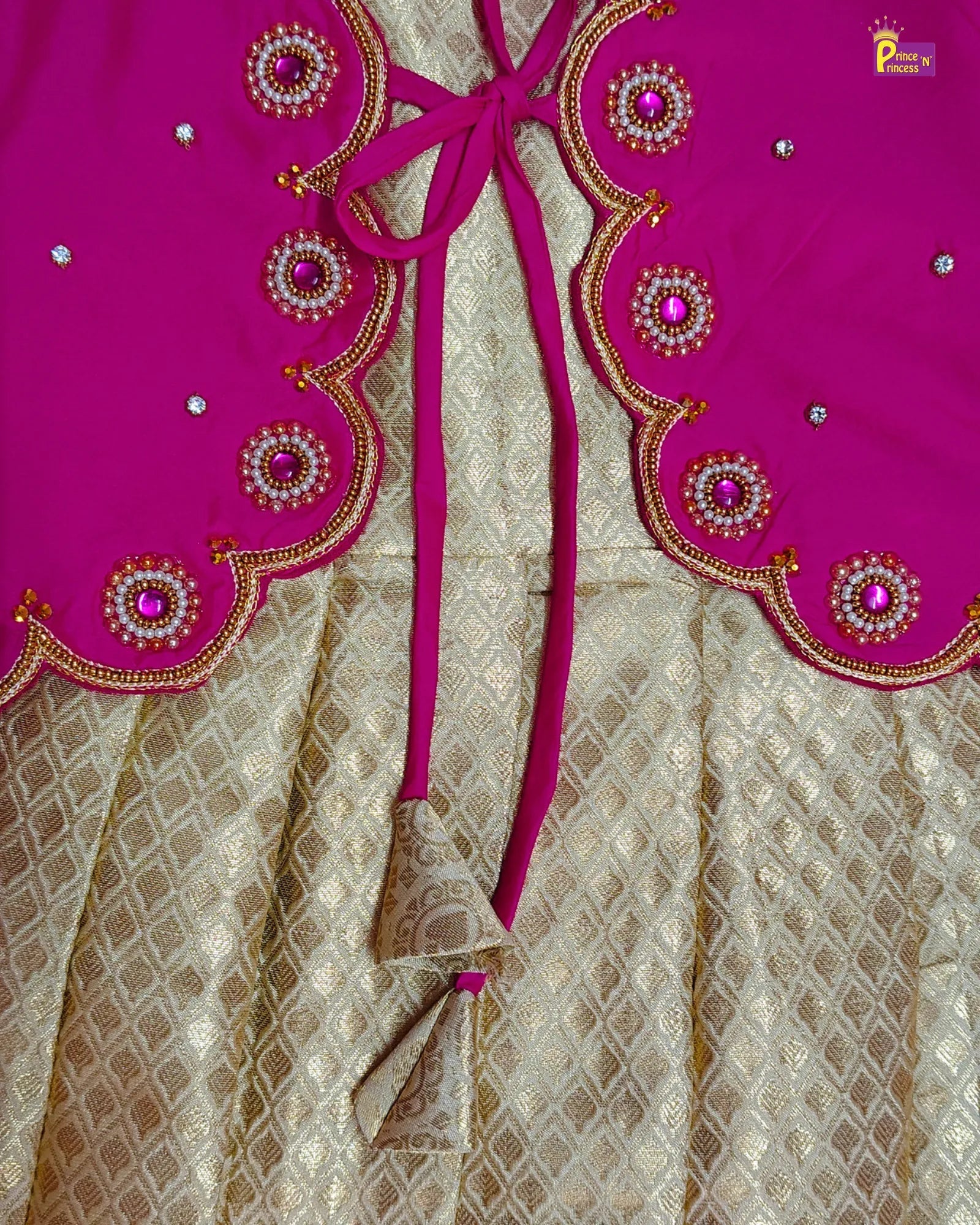 Pink embroidered fabric with a decorative bow on a beige patterned background