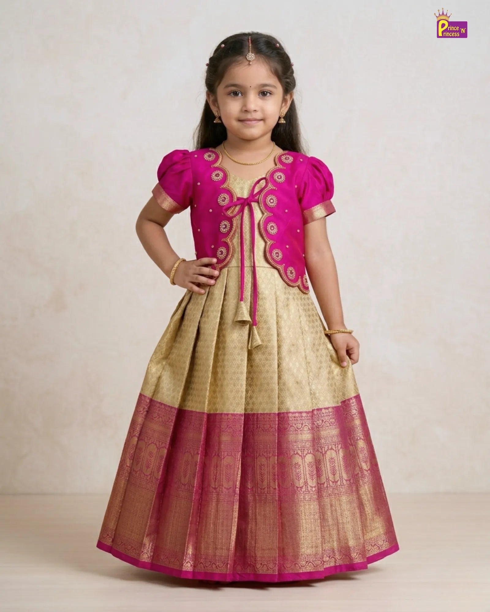 Young girl wearing a pink and gold traditional outfit on a plain background