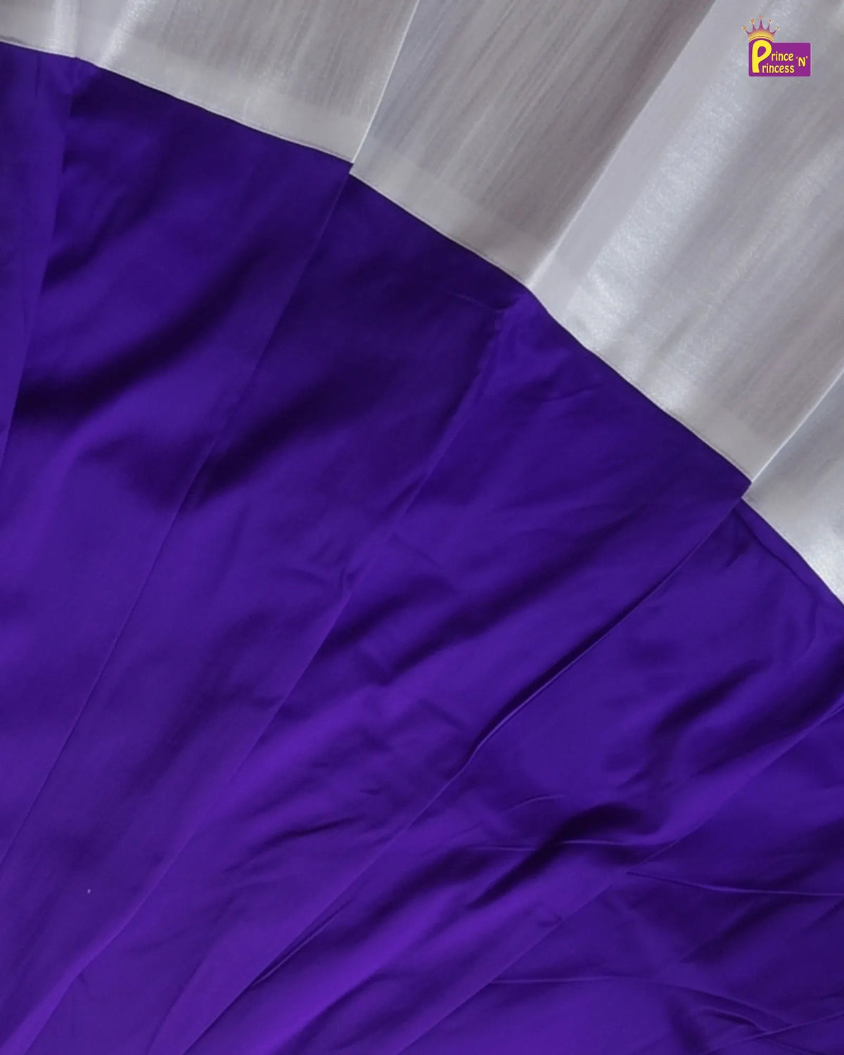 A close-up of a purple fabric with a contrasting white border, showing the texture and drape of the material.