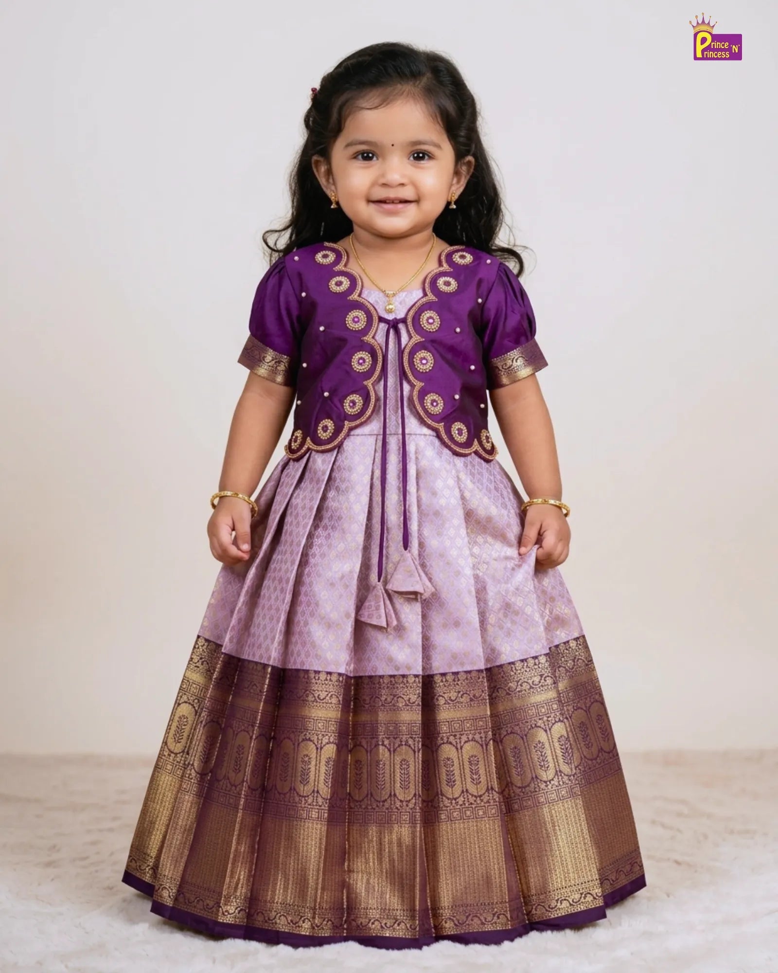 Young girl wearing a traditional outfit with purple and brown colors on a white background