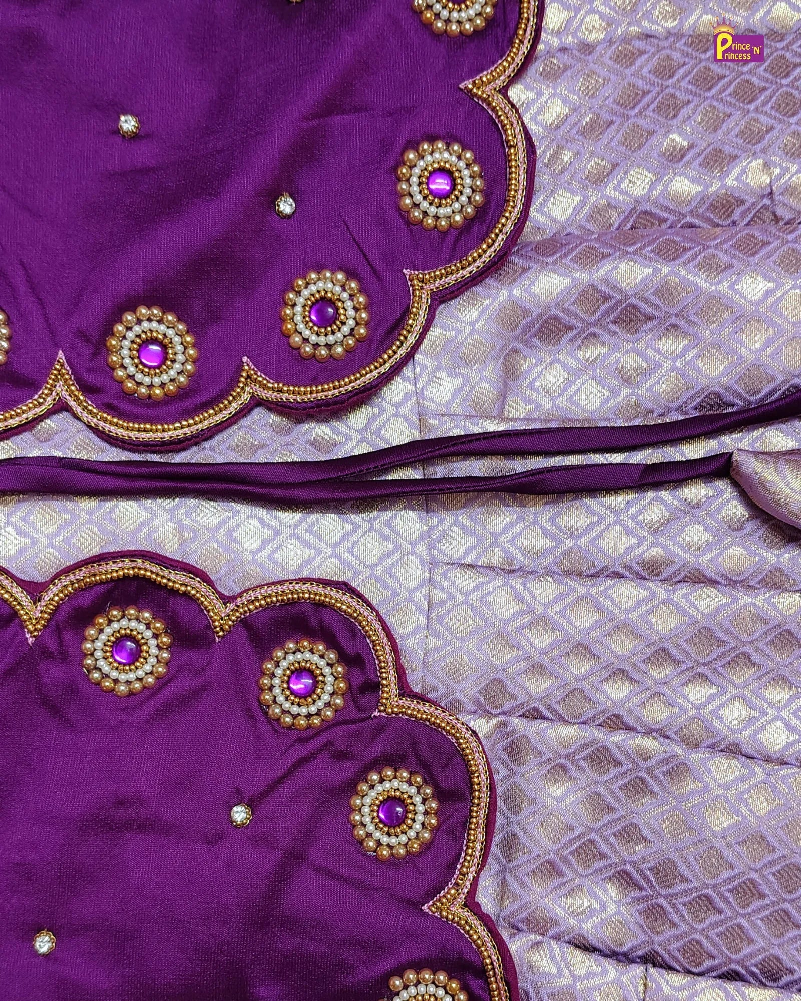 Purple fabric with gold and pink embellishments on a matching purple background
