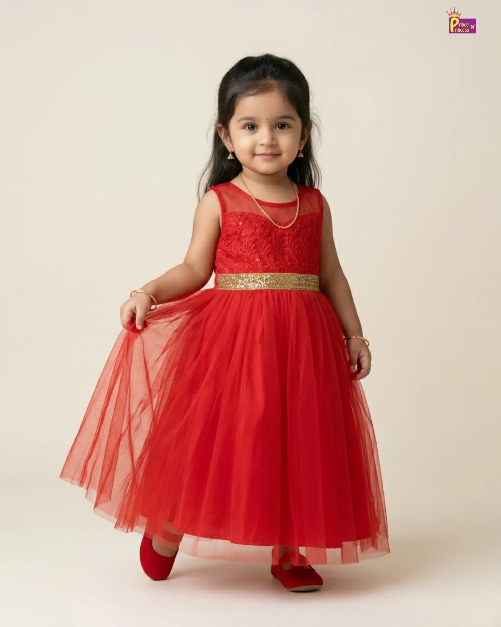 Young girl wearing a red dress with a gold belt on a beige background