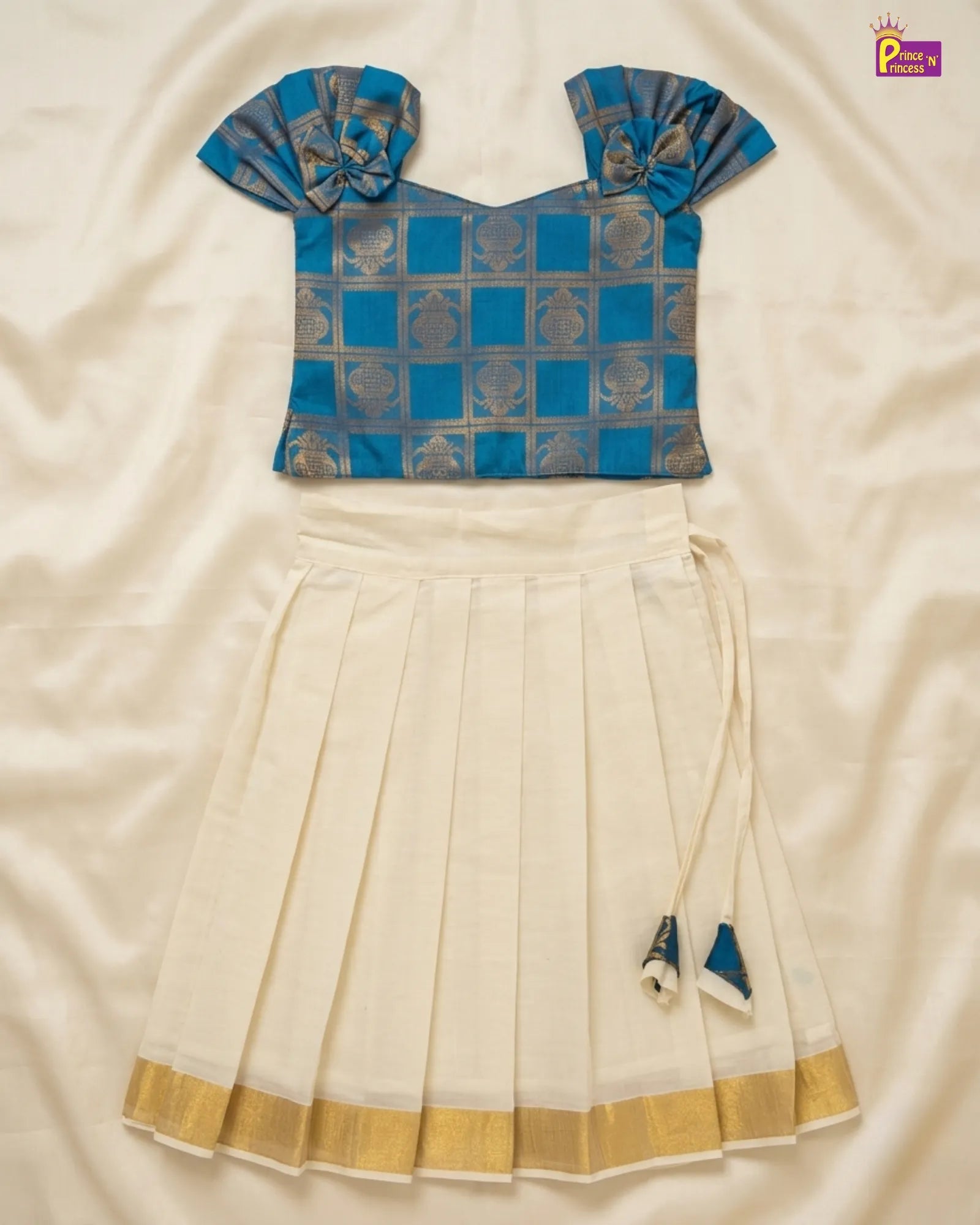 Blue blouse with a white saree on a beige fabric background