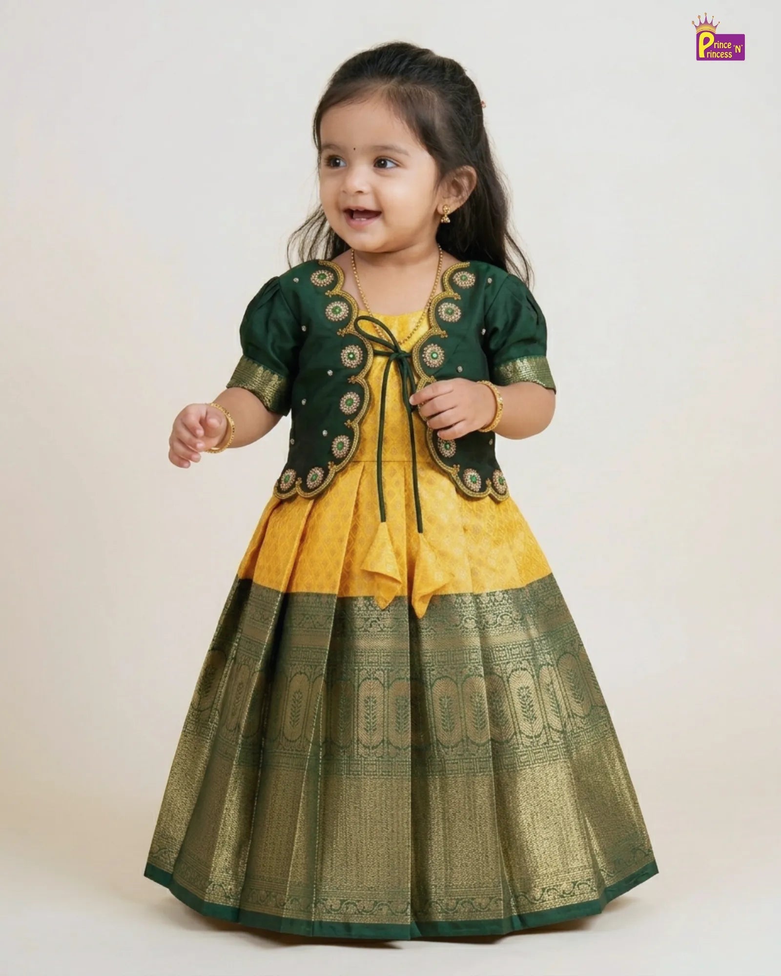 newborn Young girl wearing a green and yellow traditional outfit on a white background