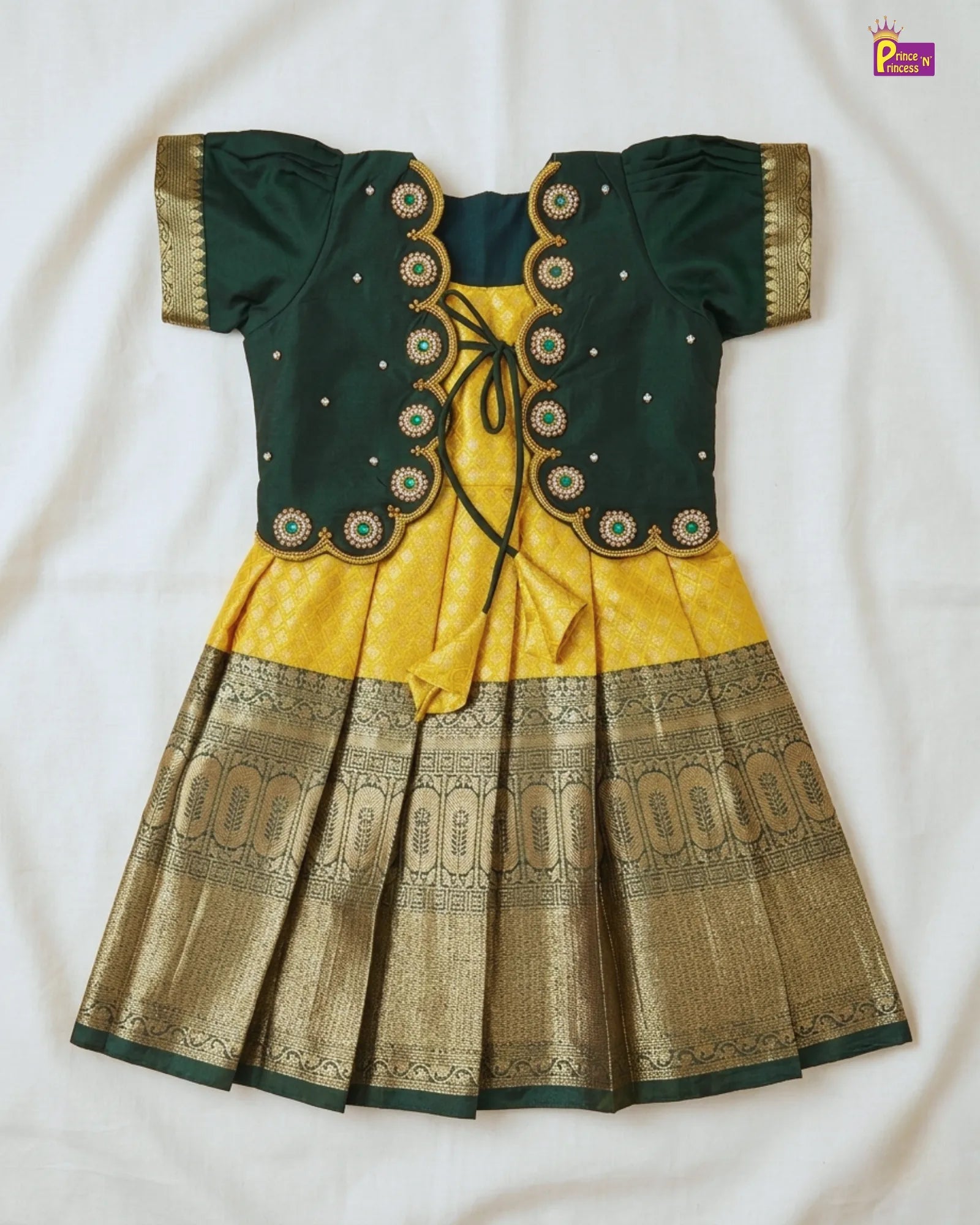 Green and yellow traditional outfit with intricate patterns on a white background