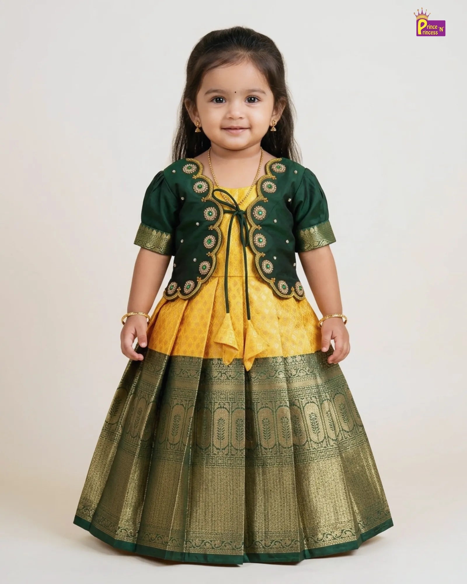 Young girl wearing a green and yellow traditional outfit on a white background
