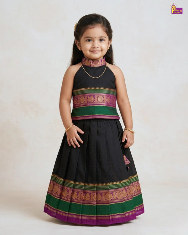 Young girl wearing a traditional outfit with a black skirt and colorful top on a white background