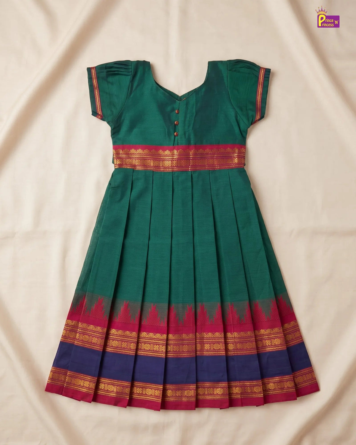 A green cotton Anarkali dress with a pleated skirt, featuring a red and gold zari border at the waist and hem, laid flat on a beige fabric background.