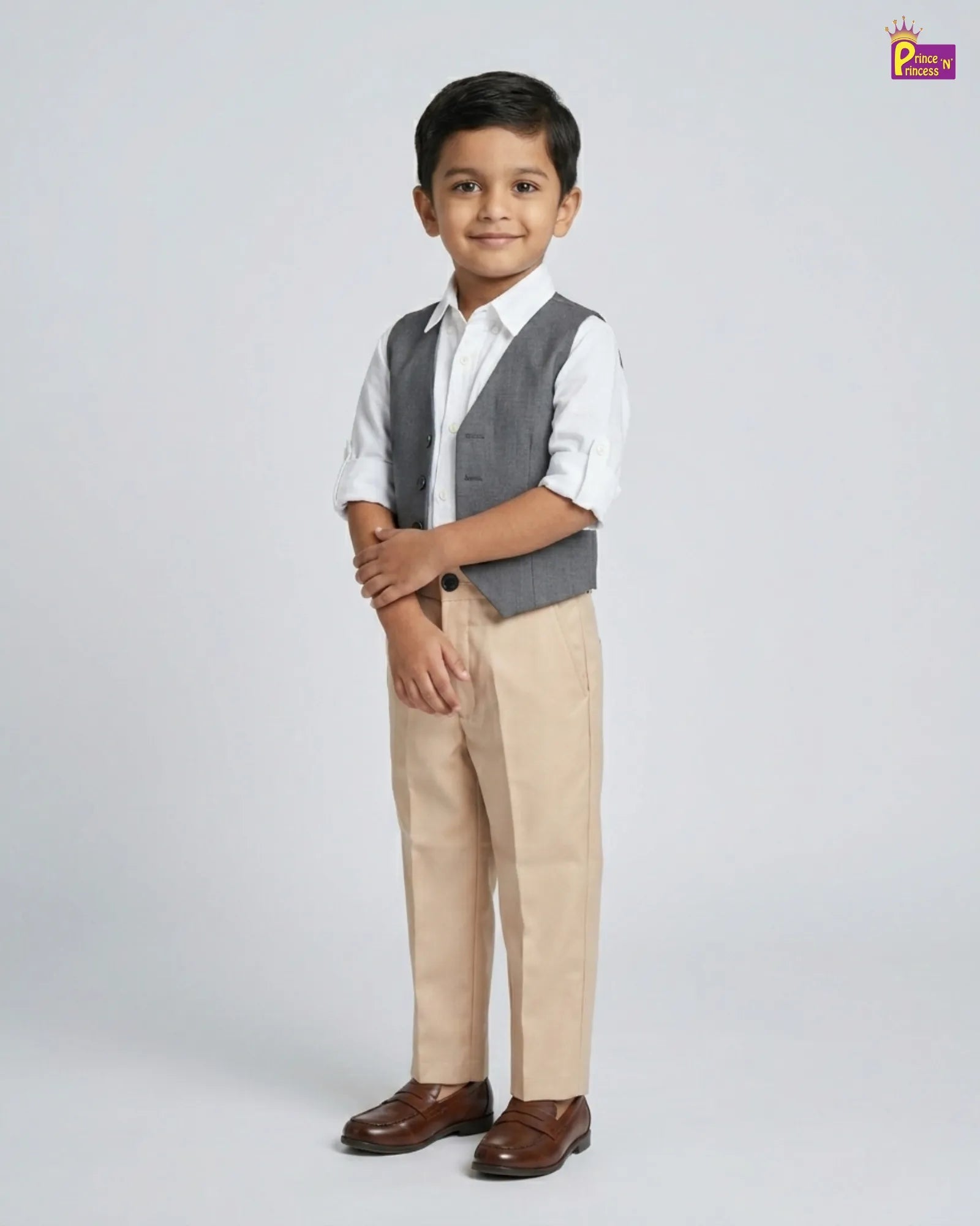 Young boy wearing a formal outfit with a vest and pants on a white background