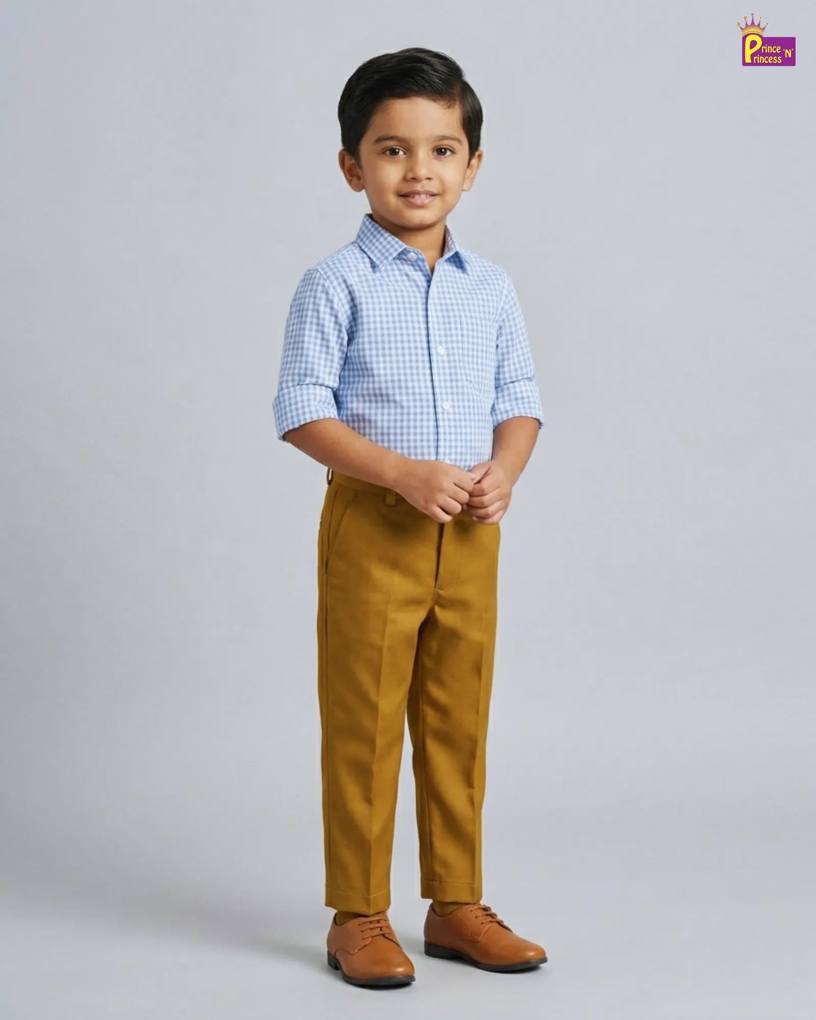 Young boy wearing a checkered shirt and mustard pants on a gray background