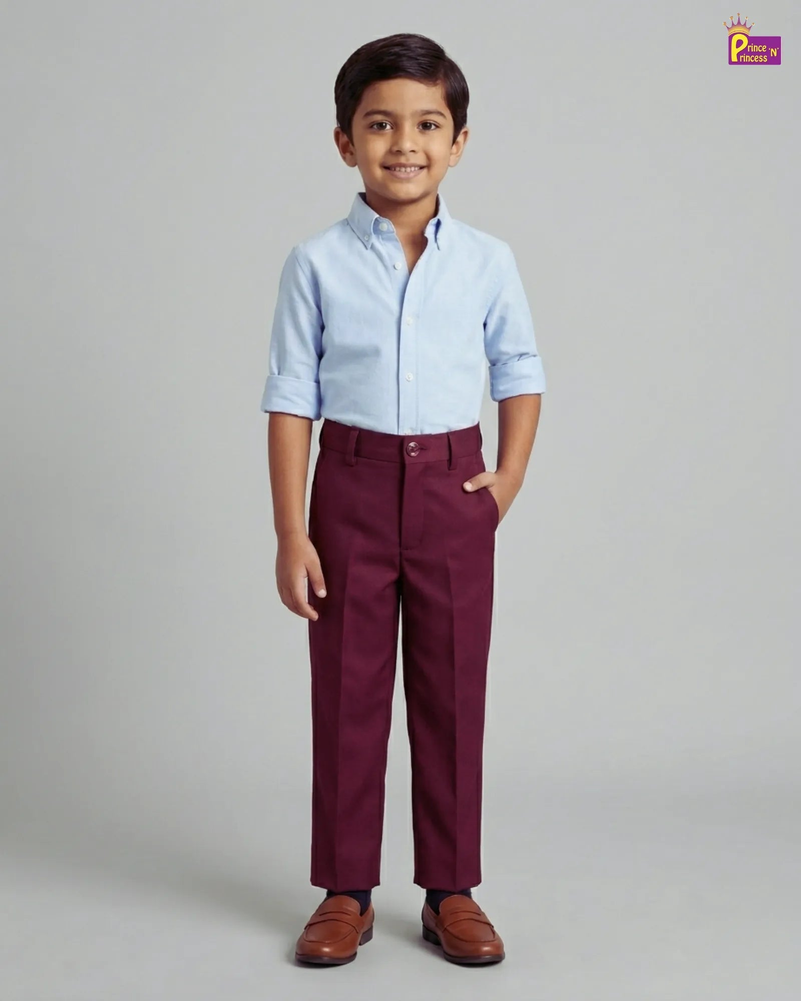 Child wearing a light blue shirt and maroon pants on a gray background