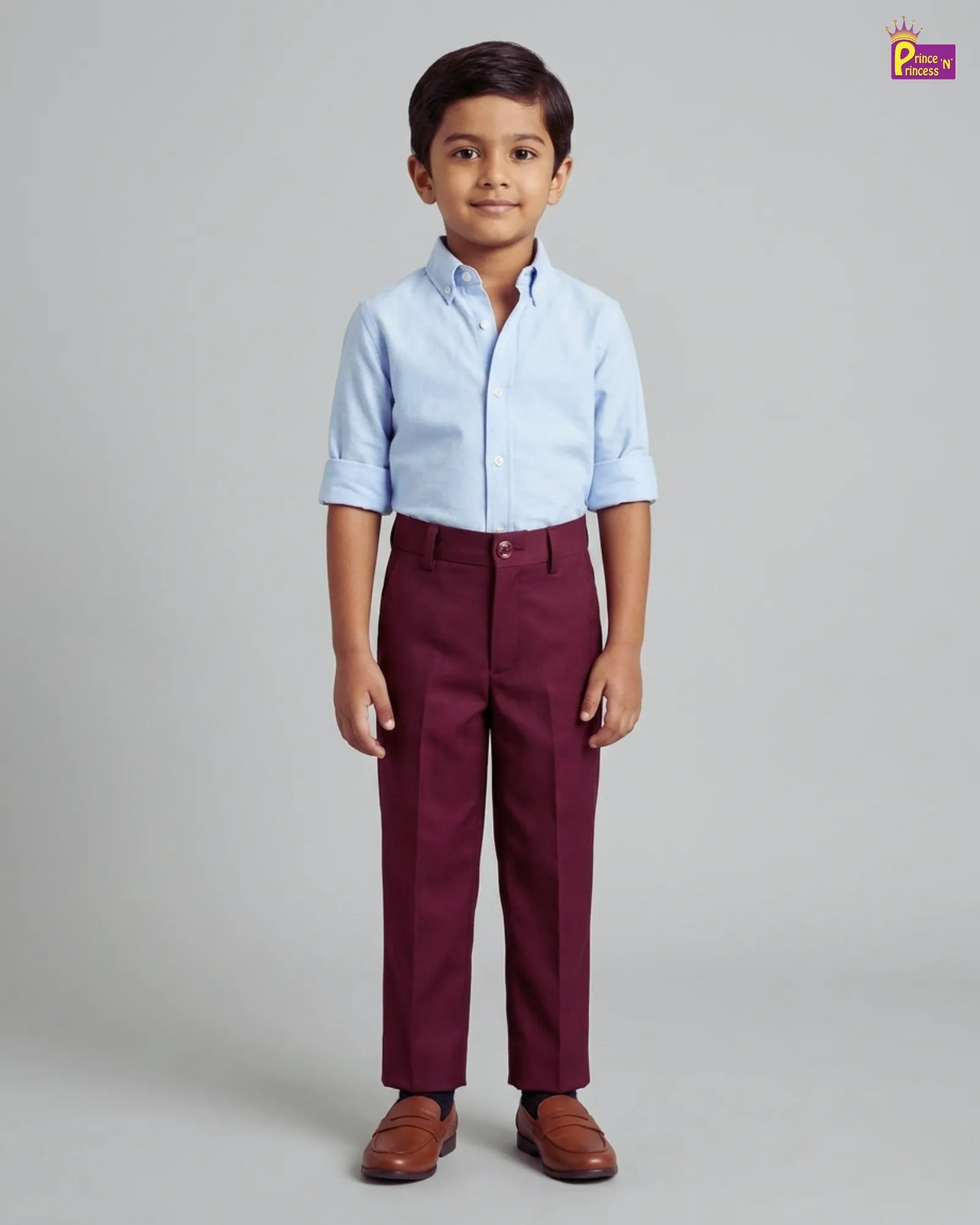 Child wearing a light blue shirt and maroon pants on a gray background