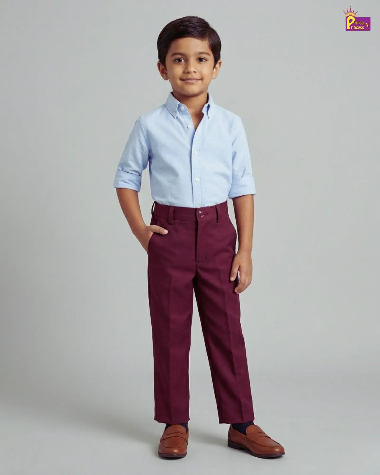Child wearing a light blue shirt and maroon pants on a gray background