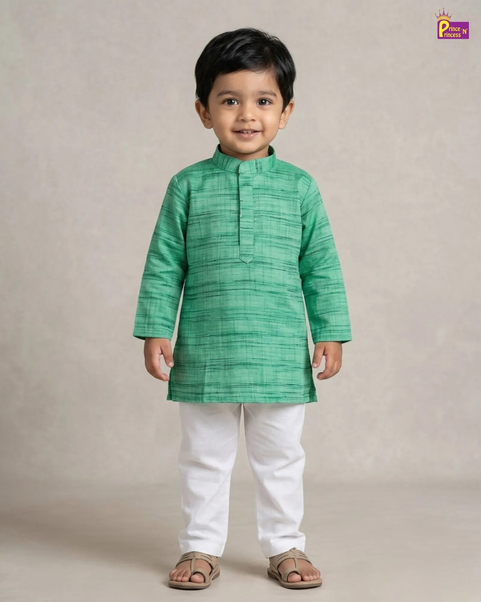 Child wearing a green kurta with white pants on a beige background
