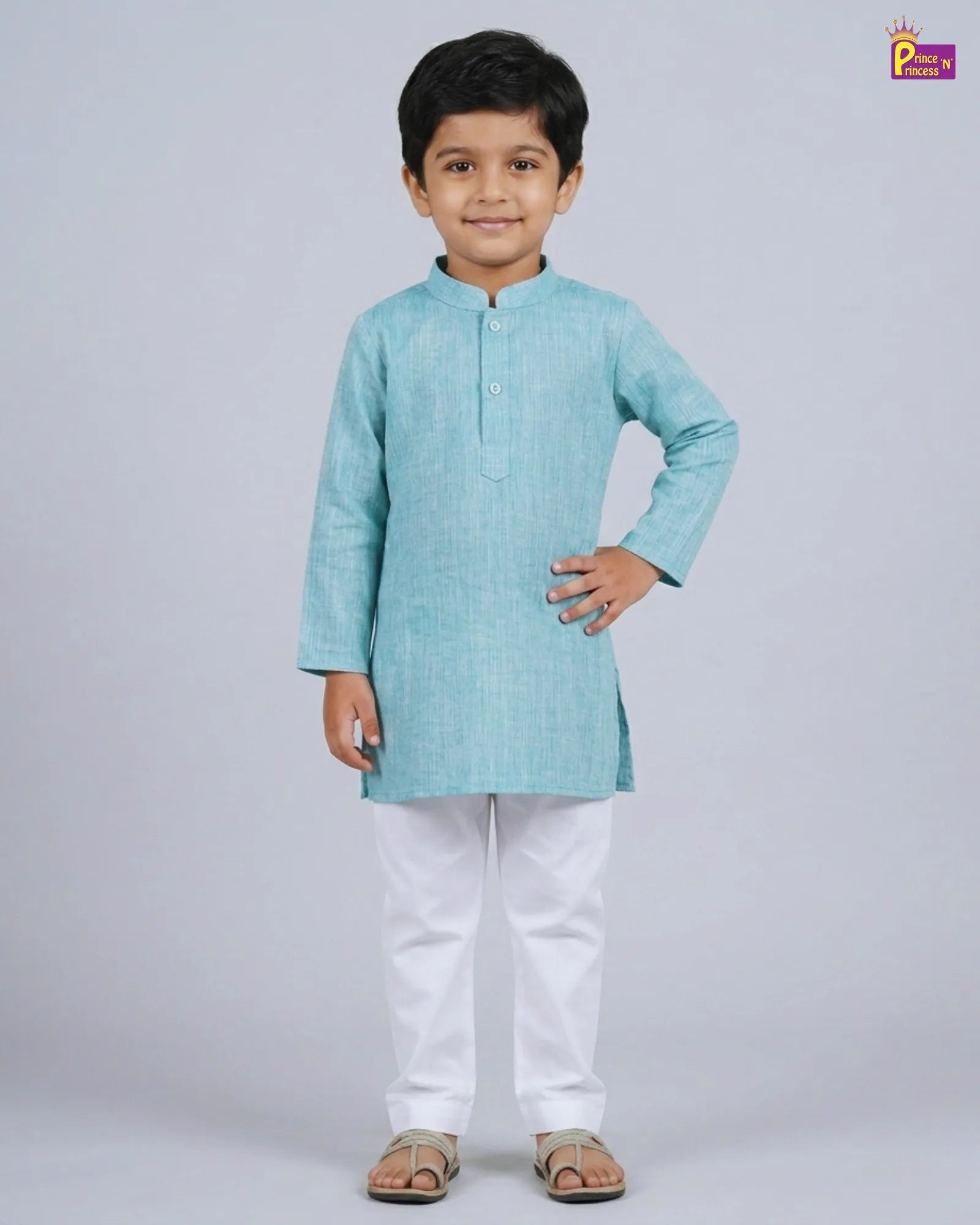 Young boy wearing a light blue kurta with white pants on a gray background