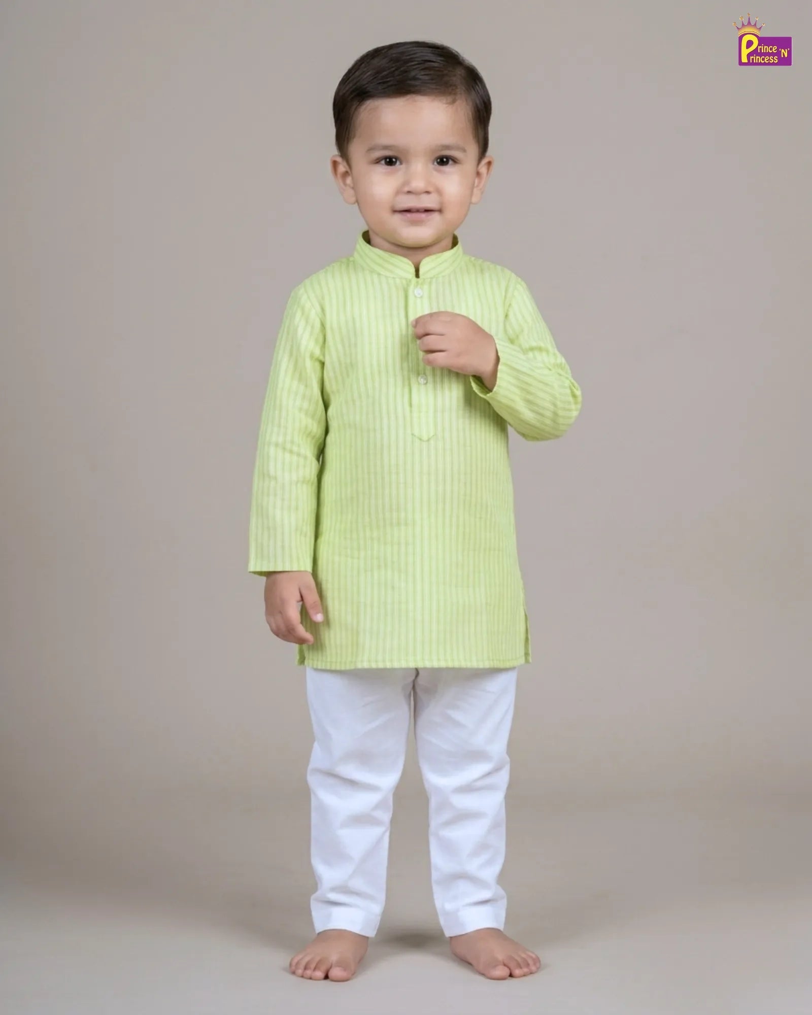 Child wearing a light green kurta with white pants on a beige background