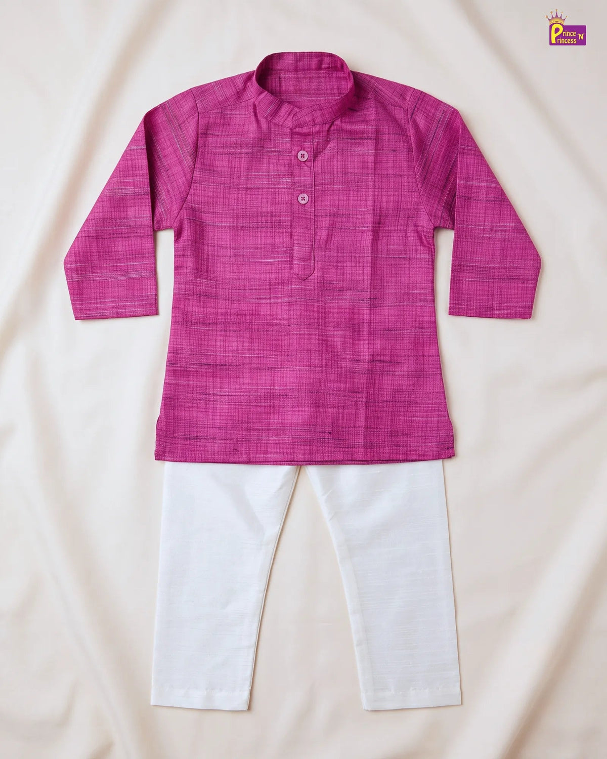 A children's two-piece outfit laid flat on a cream fabric background, featuring a bright pink textured long-sleeve kurta with a collar and three buttons, paired with white pants.
