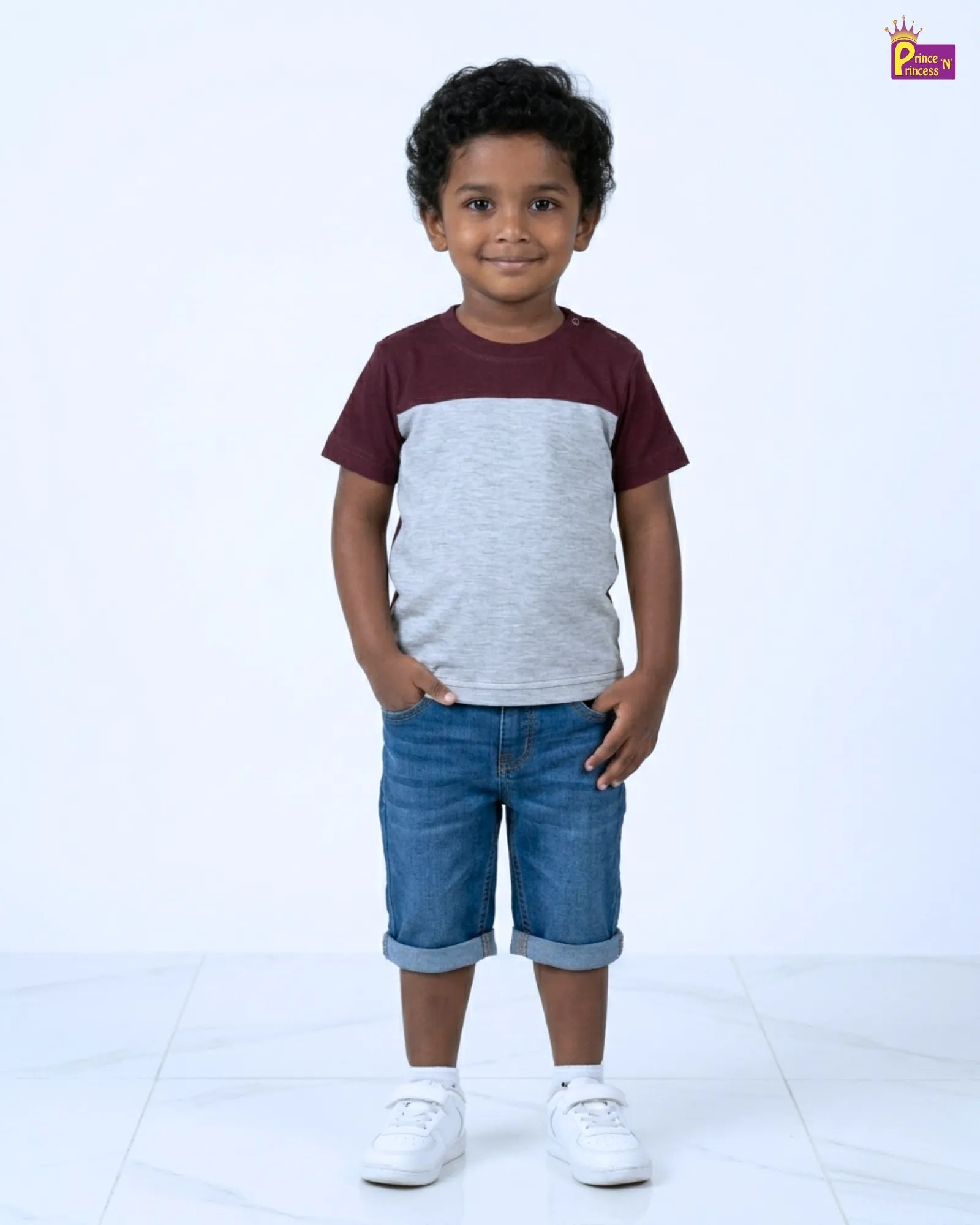 Child wearing a two-tone shirt and denim shorts on a white background