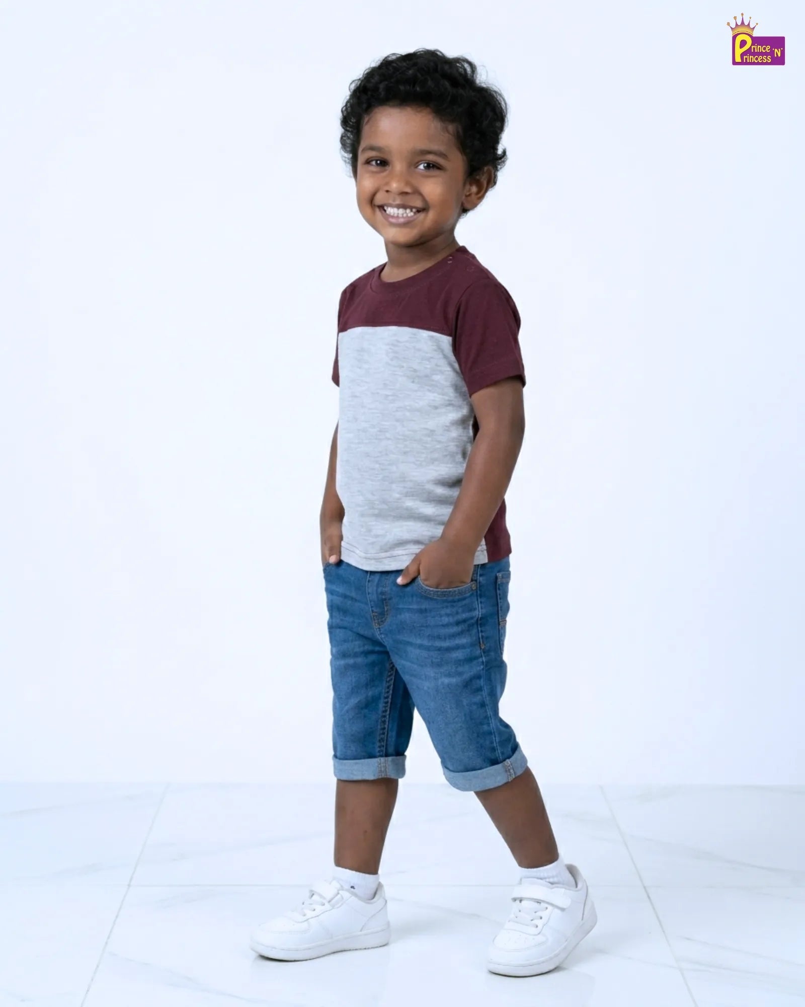 Child wearing a two-tone shirt and blue shorts on a white background