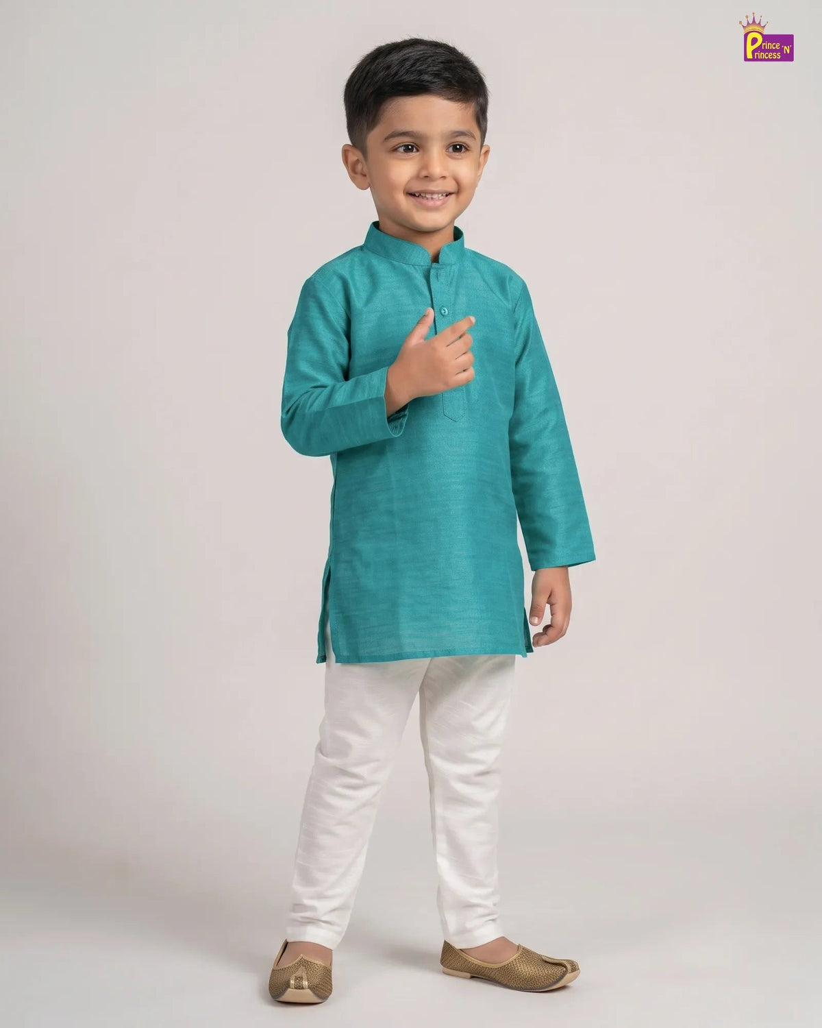 A young boy modeling a teal green kurta with white pants and beige shoes, standing against a light gray studio background. A small 'Pichwai' brand logo is visible in the top right corner.