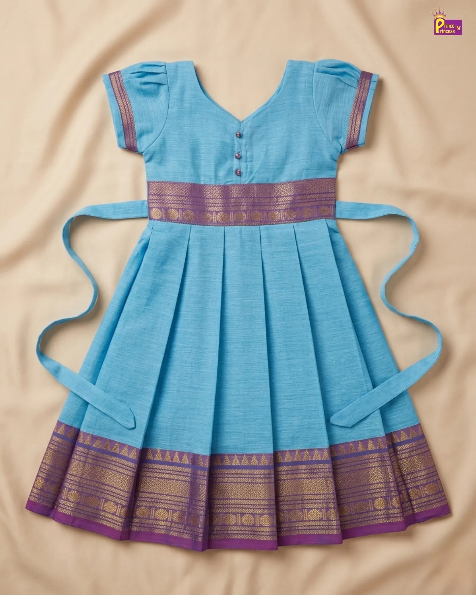 Blue dress with purple and gold accents on a beige background