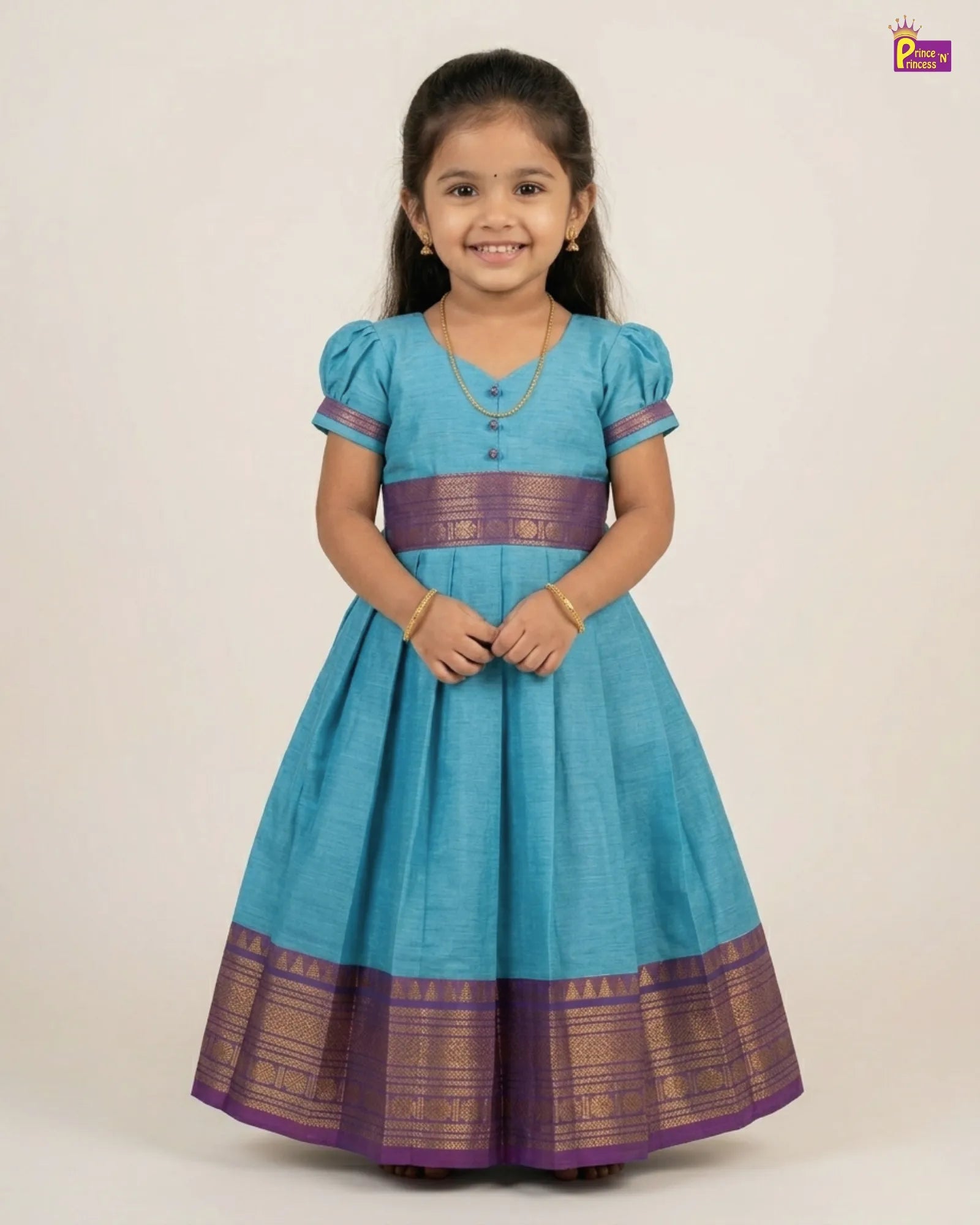 Young girl wearing a blue and purple traditional dress on a plain background