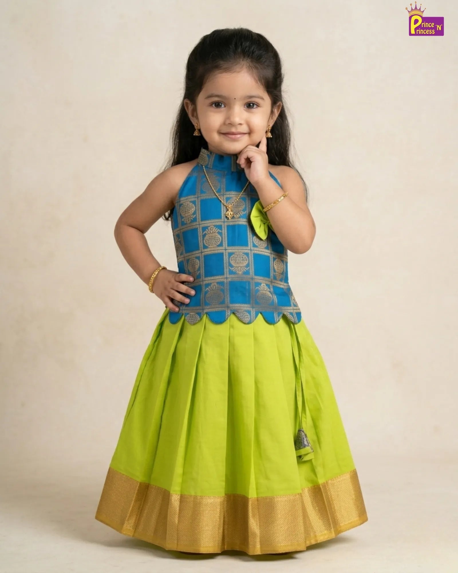 Young girl wearing a green and blue traditional outfit on a beige background