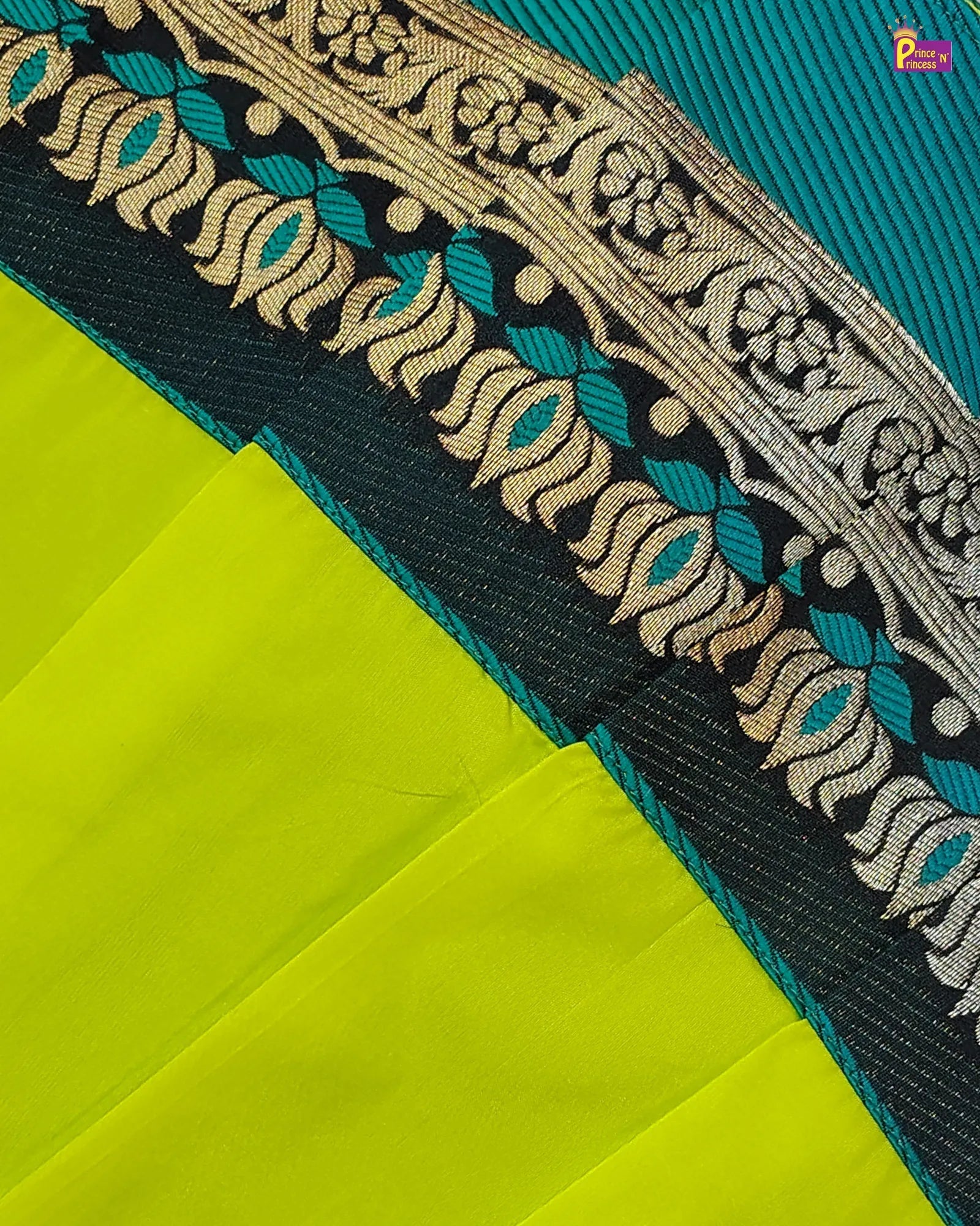 Close-up of a green fabric with intricate gold and blue embroidery