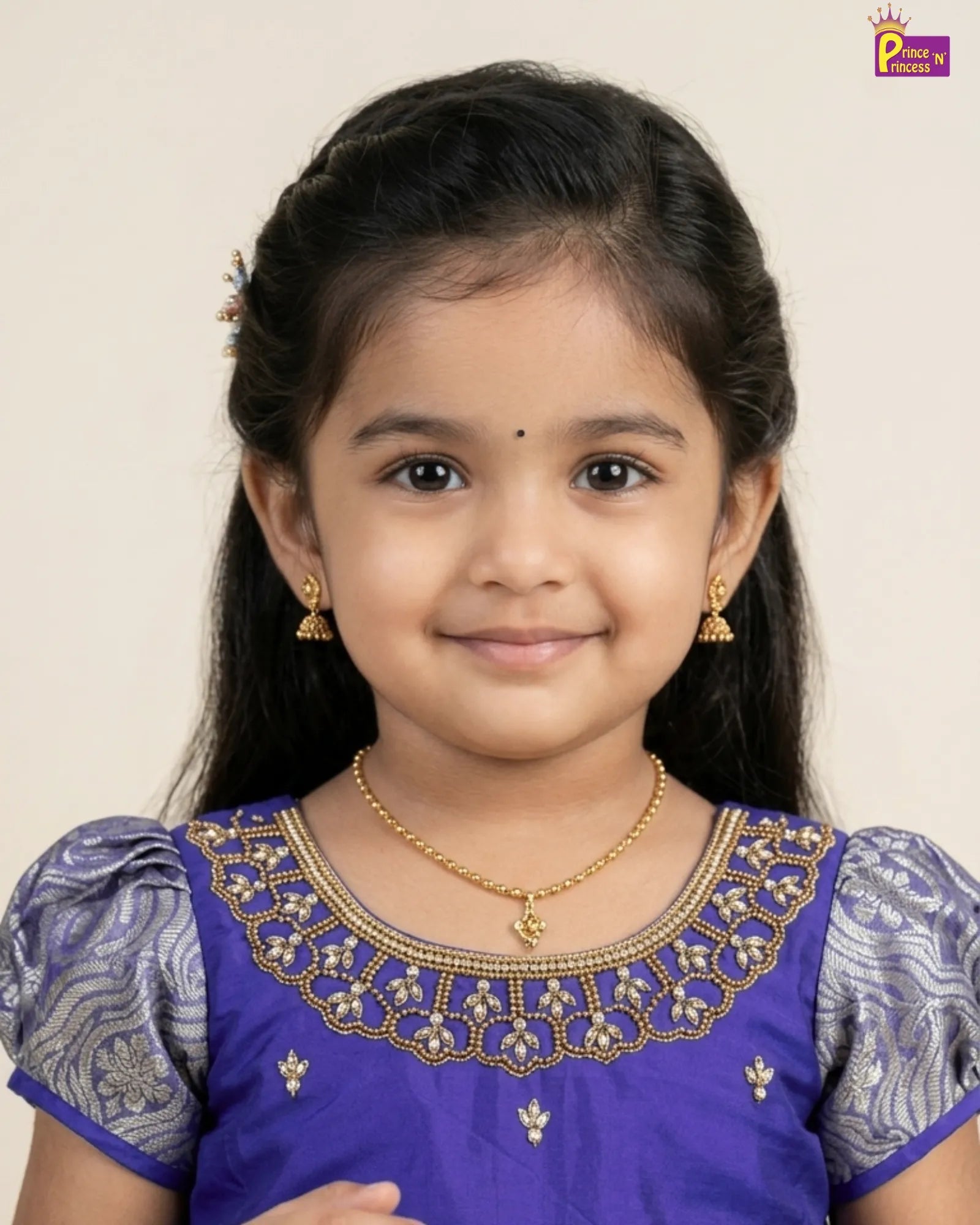 Young girl wearing a traditional outfit with gold jewelry against a plain background