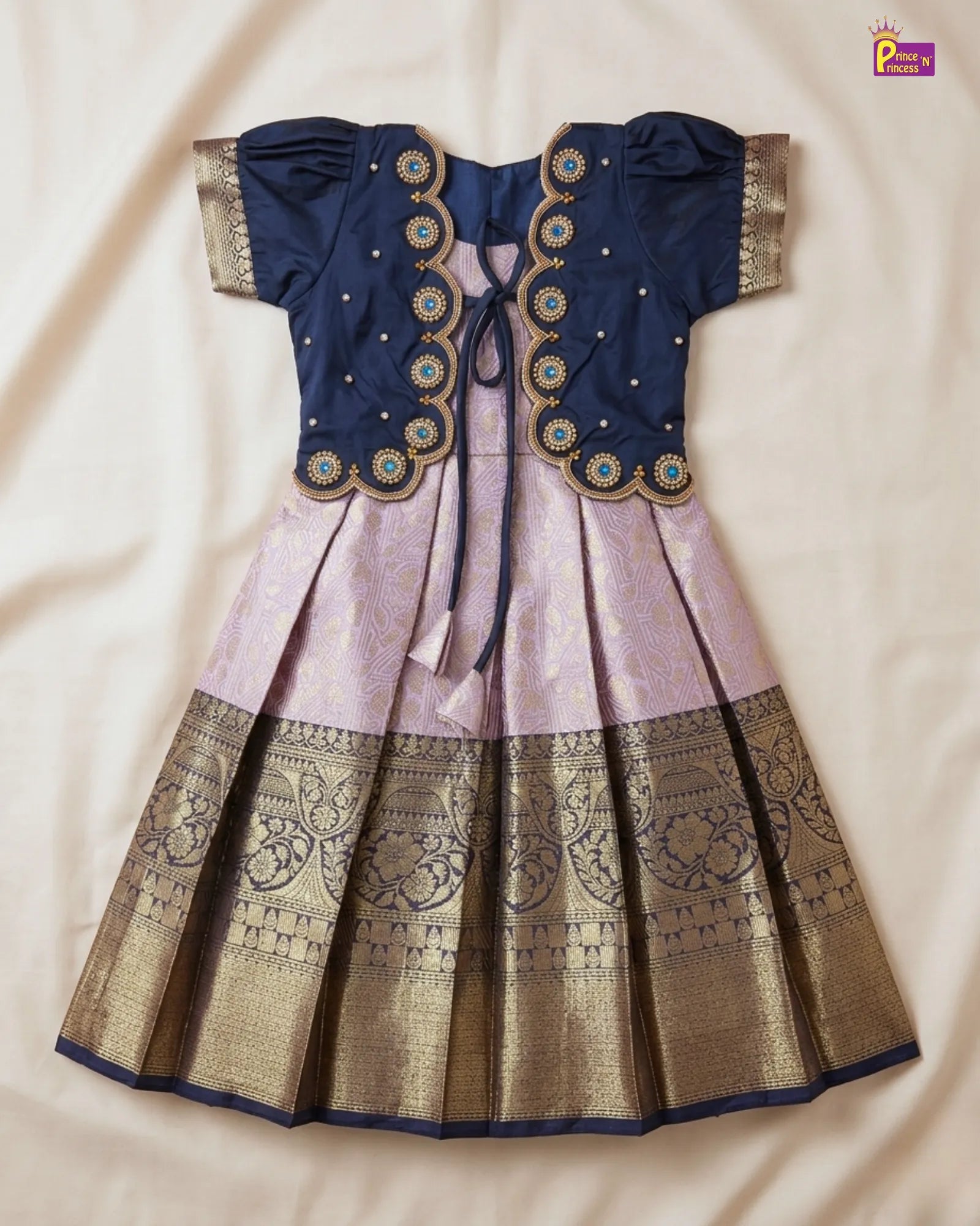 Traditional outfit with blue blouse and pink and gold skirt on a beige background