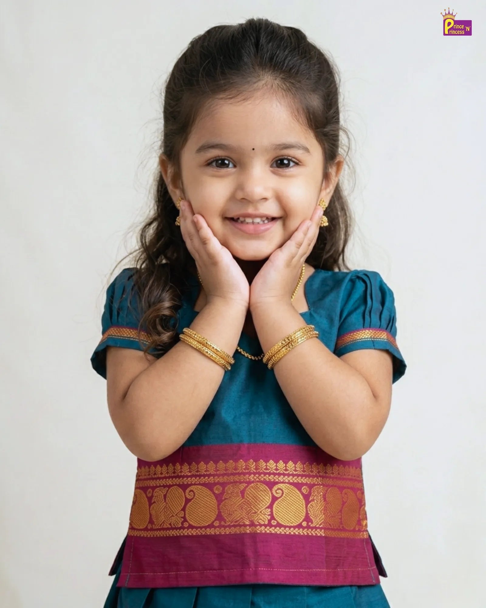 Young girl wearing a traditional outfit with gold bangles on a white background