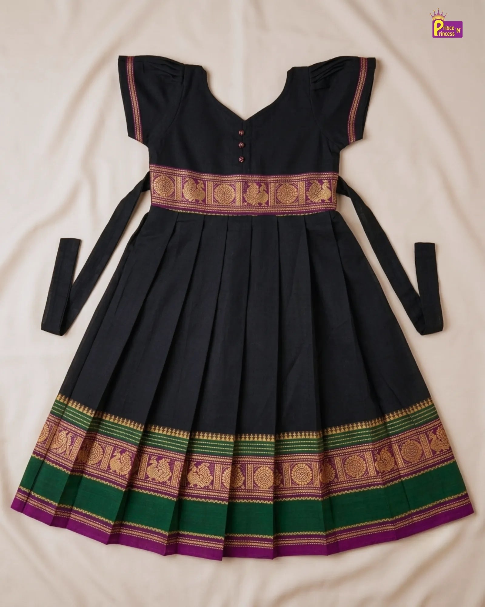 Black dress with green and gold patterns on a white background