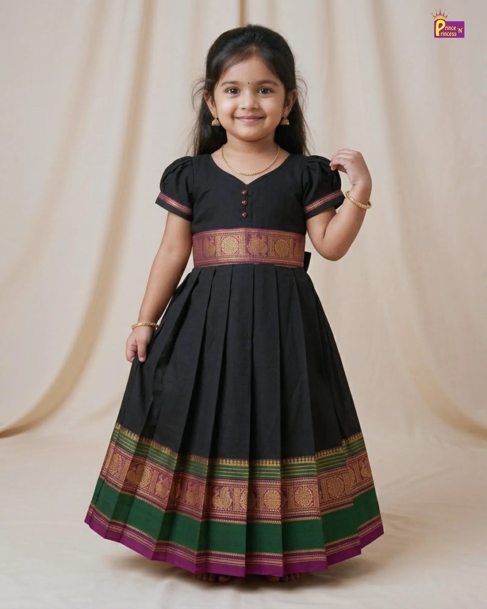 Young girl wearing a black dress with colorful patterns on a beige background