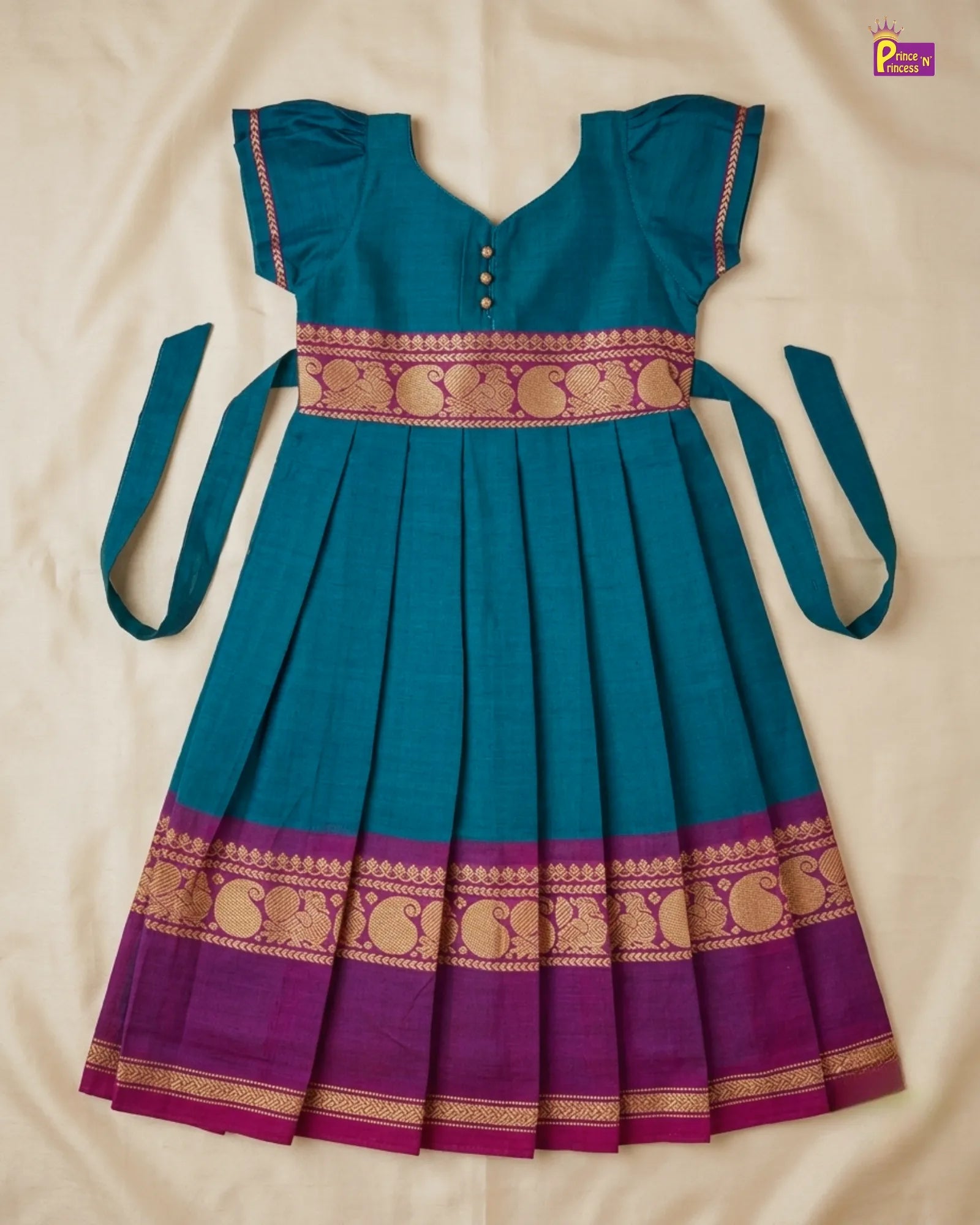 Teal and purple traditional dress with gold patterns on a beige background